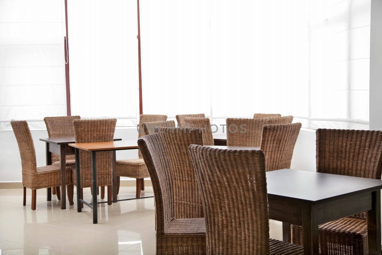 room with empty wood chairs and tables