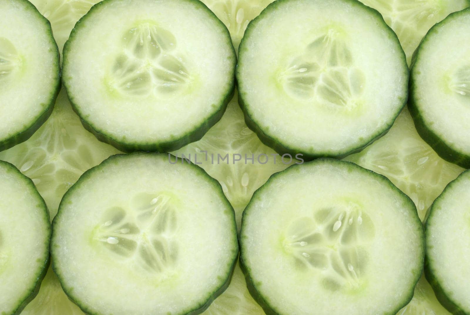 Many cucumber slices filling the frame to create a background.