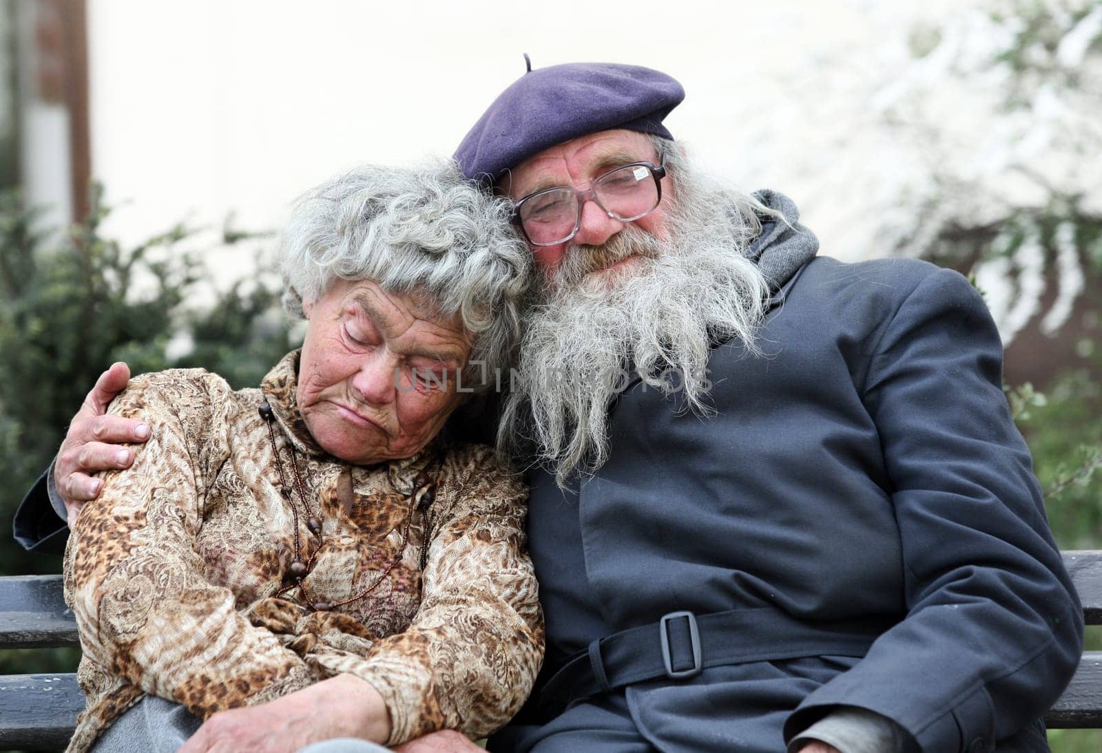 An old homeless cpuple sleeping on a bench