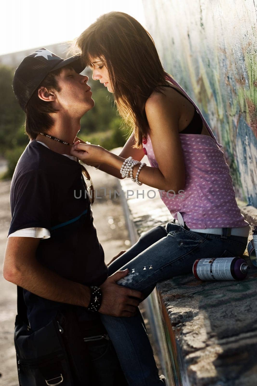Two teenagers having an intimate moment, with a graffiti background