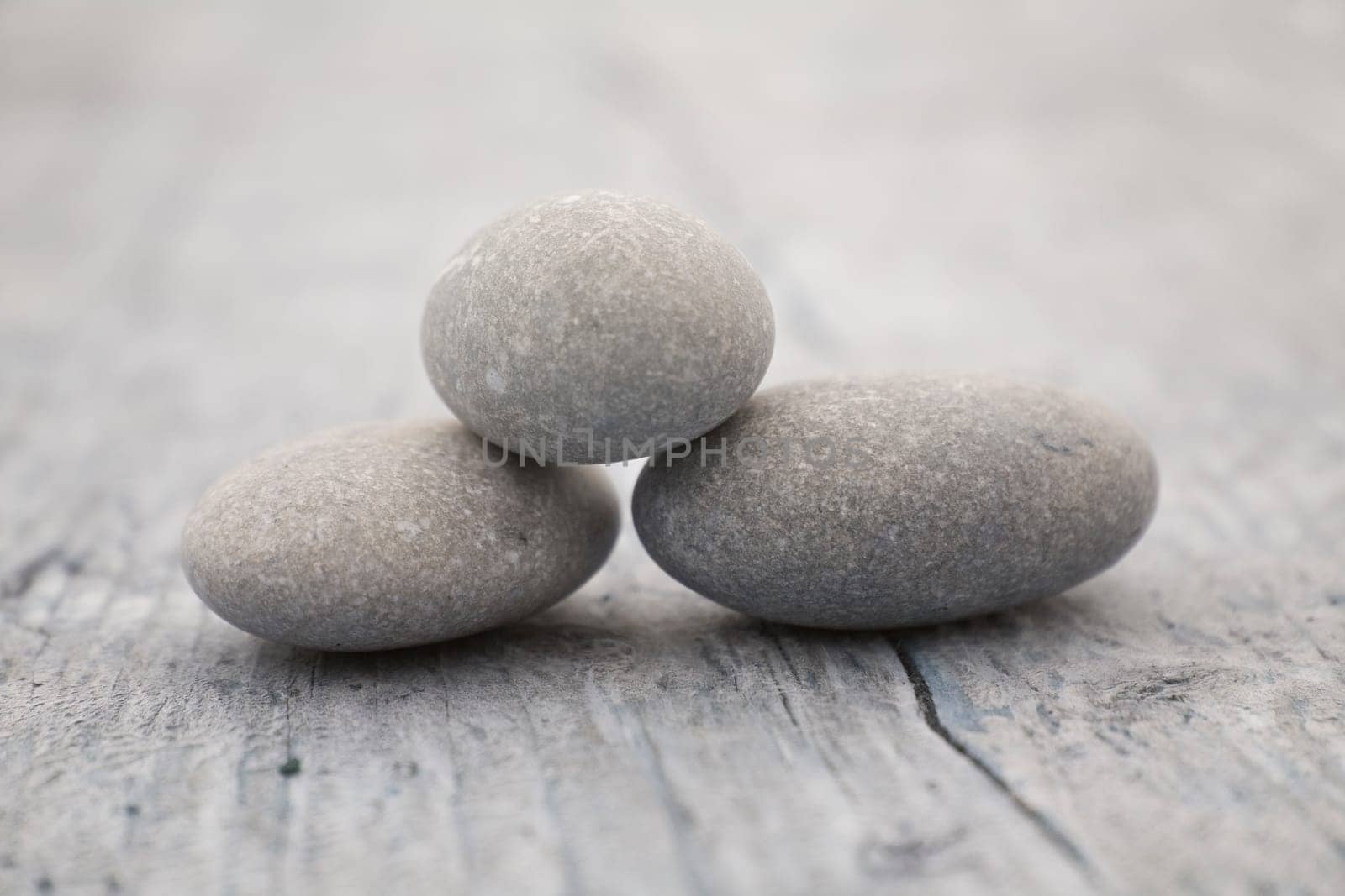 three round and soft stones on a old piece of wood