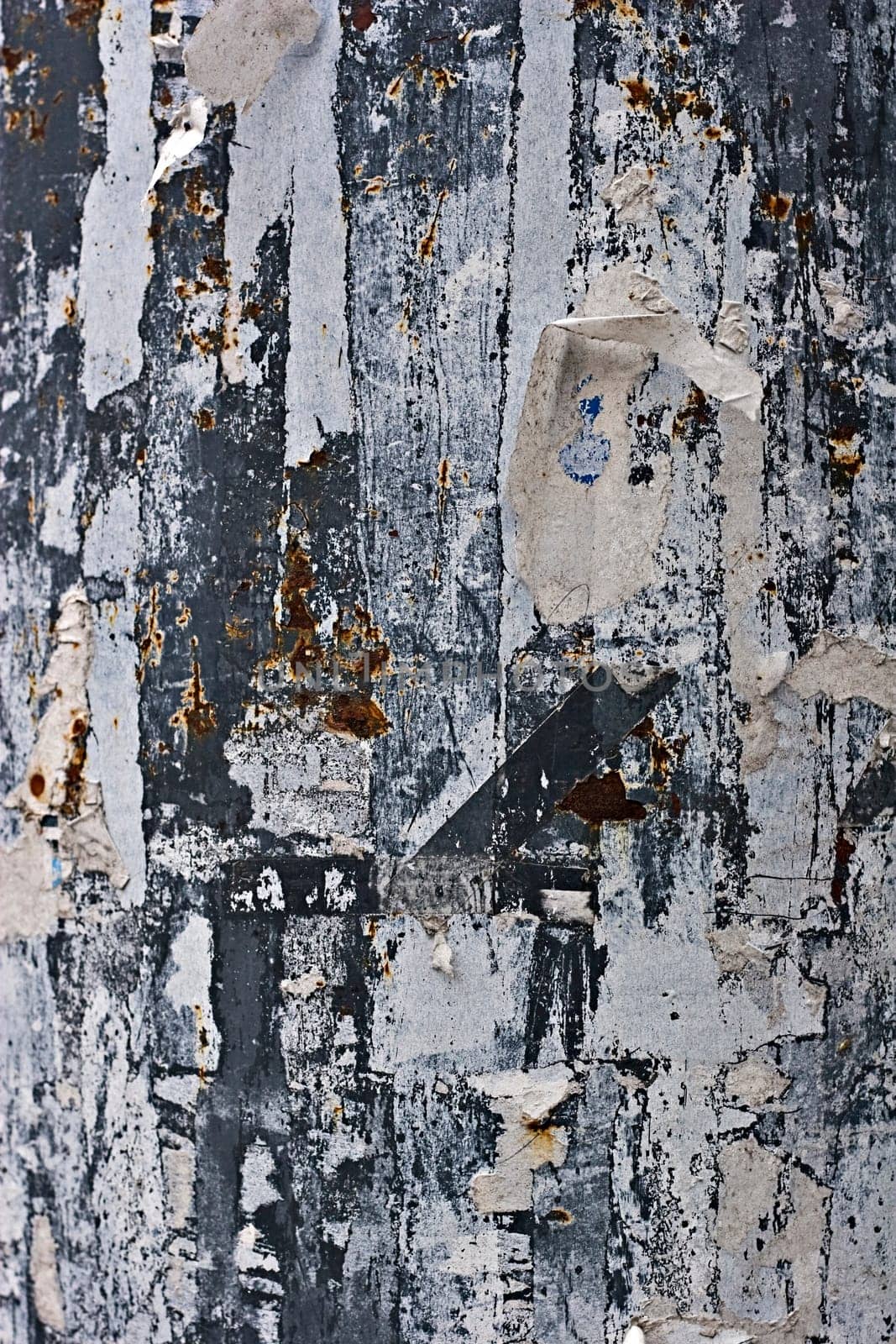 leftovers of torn paper on a metal wall