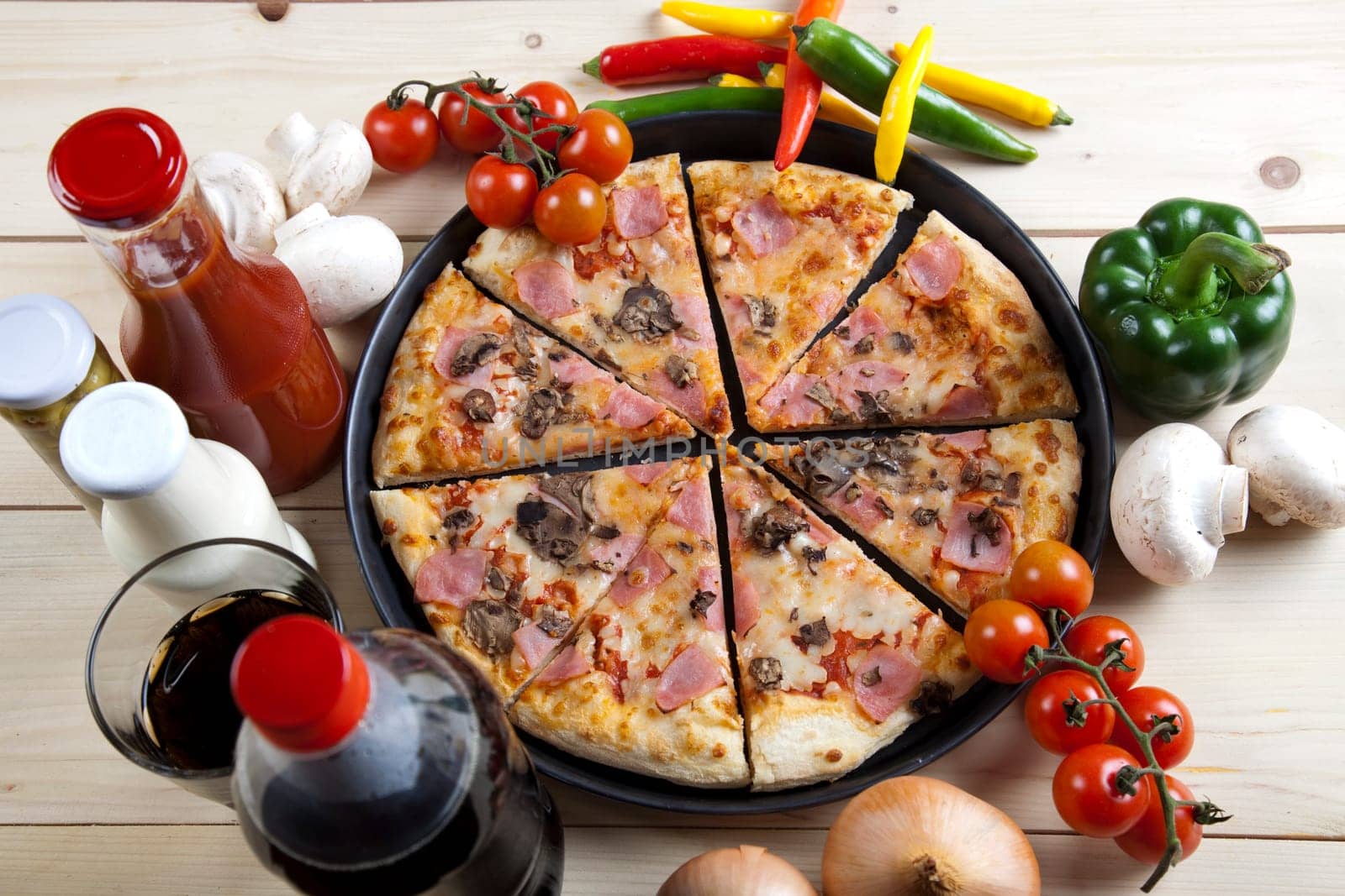 A couple of delicious pizzas, with raw tomatoes, green peppers and mushrooms