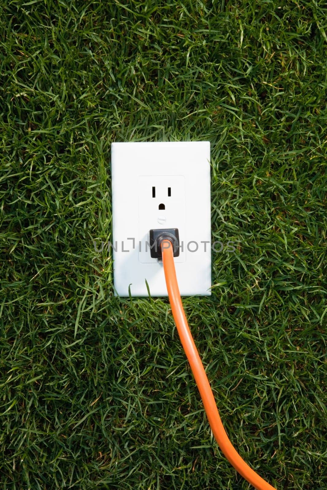 Electrical outlet in grass with extension cord plugged in