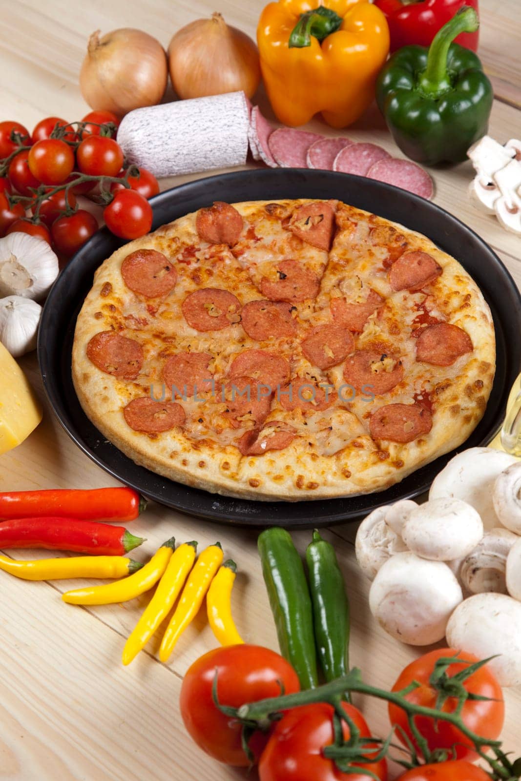 A couple of delicious pizzas, with raw tomatoes, green peppers and salami