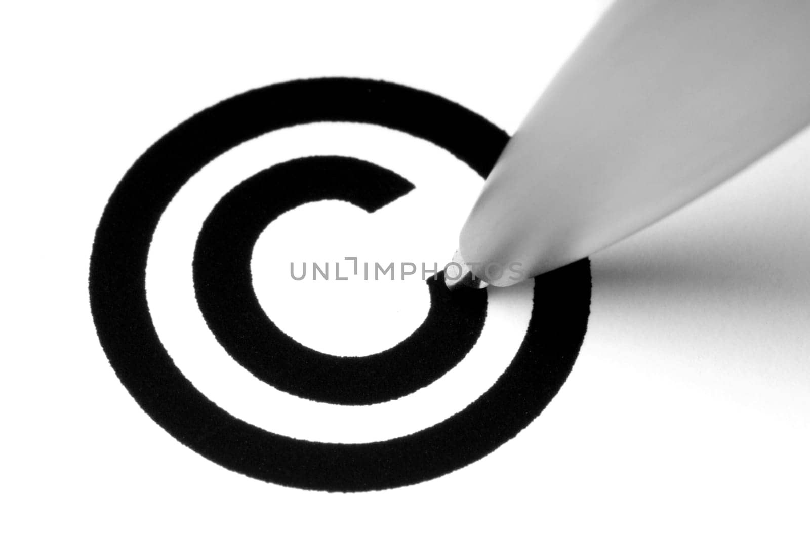 Copyright sign with tip of pen, on white.