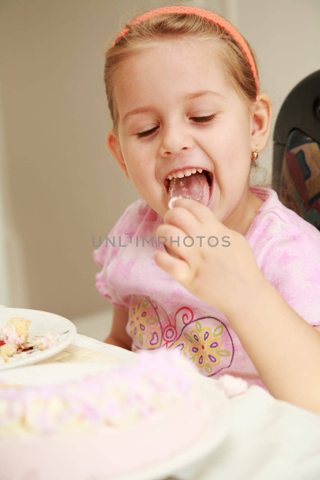 Cute girl testing her birthday cake with cream