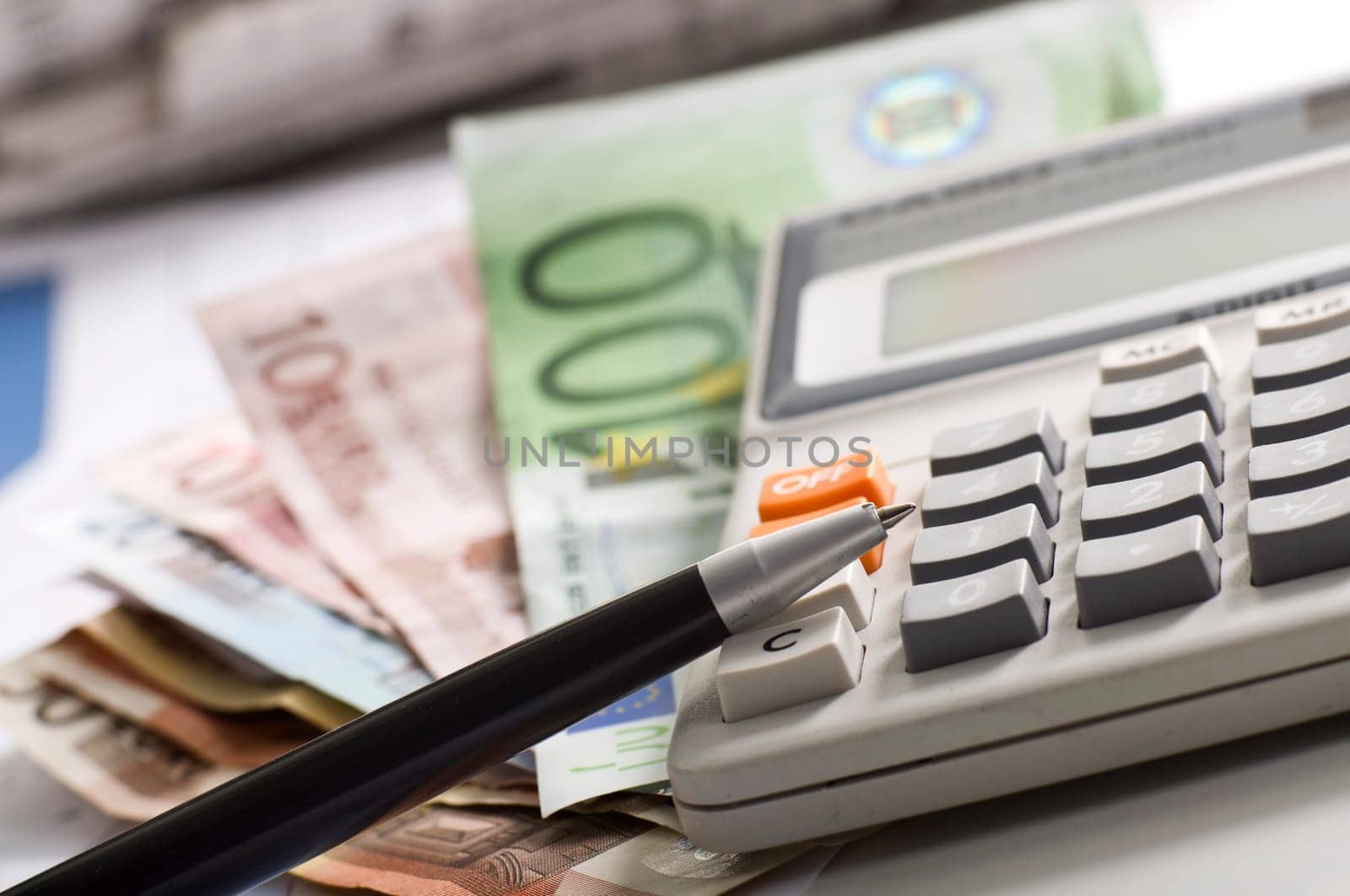 news papers with dollars and a pocket calculator