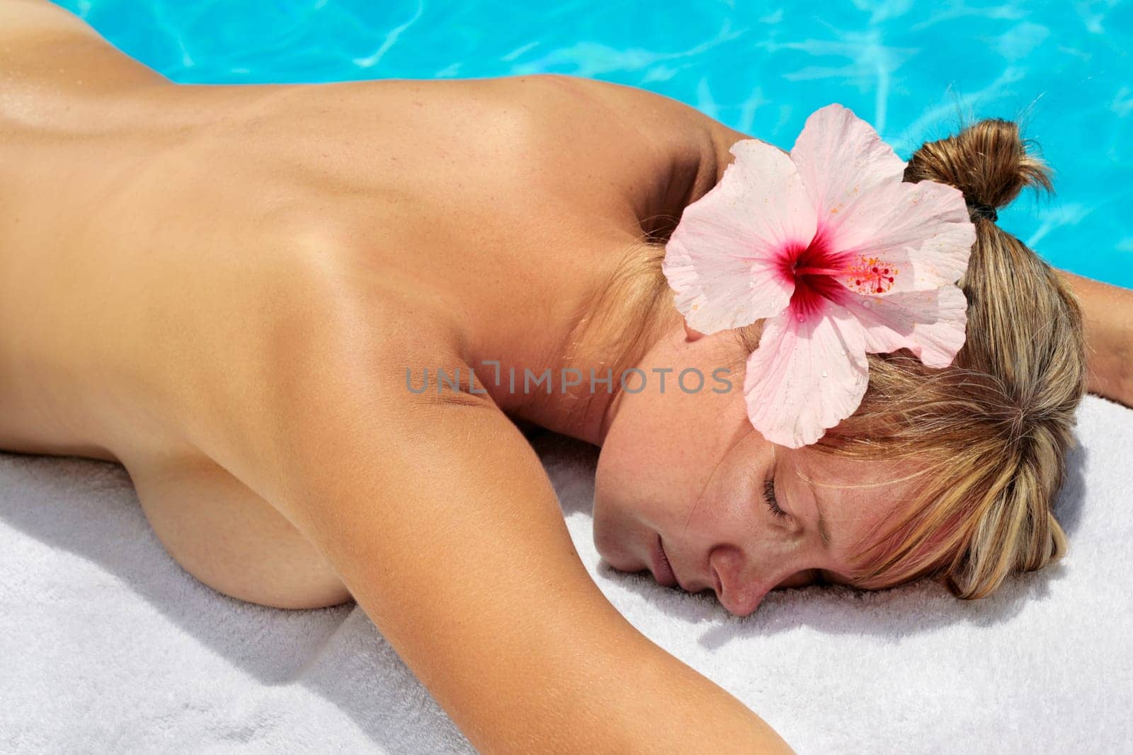 Woman with massage stones by a blue pool