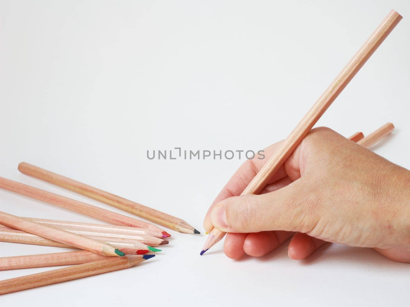 human hand ready to write with color pencils