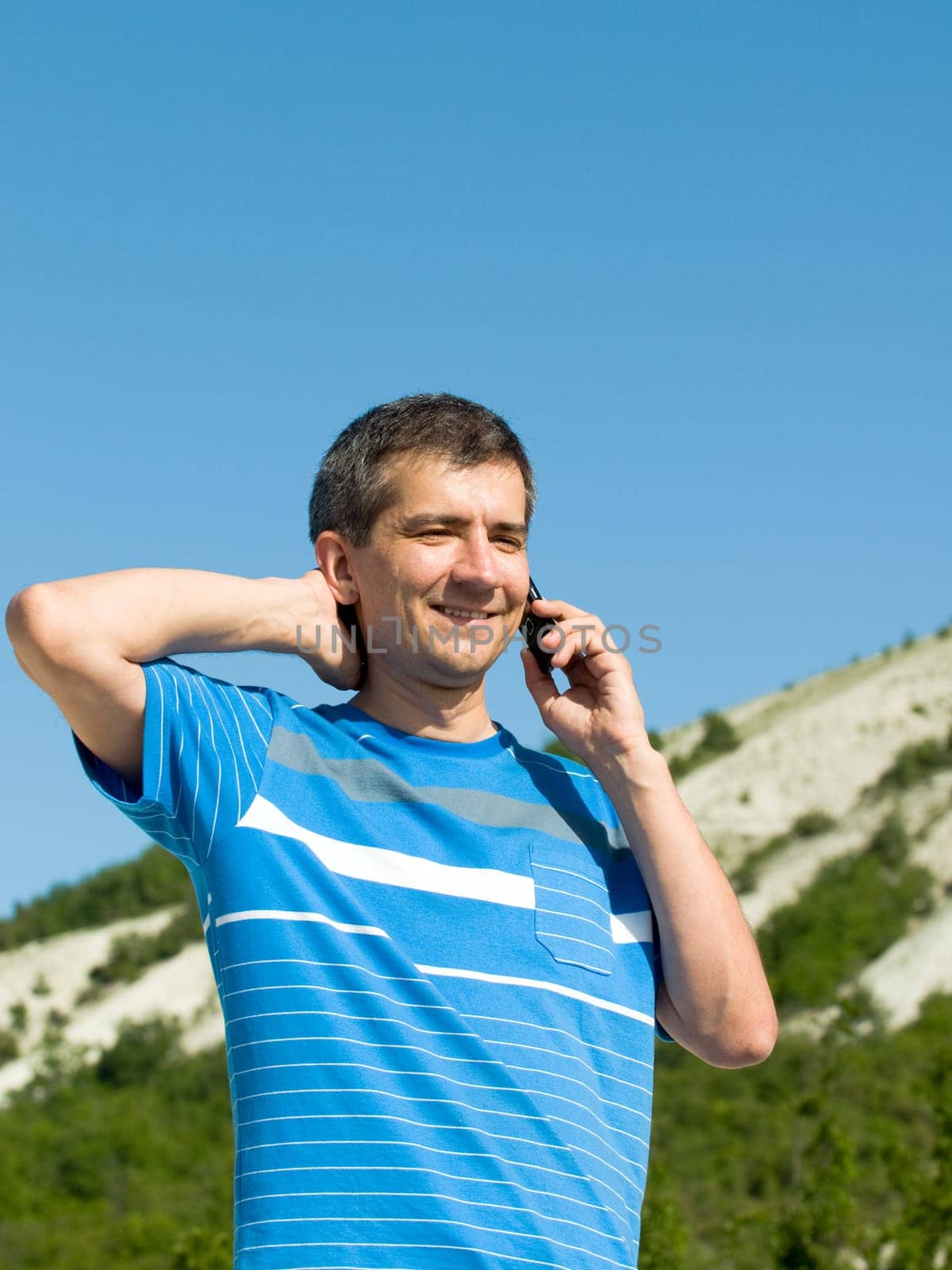 a man is talking on the mobile at the mountains