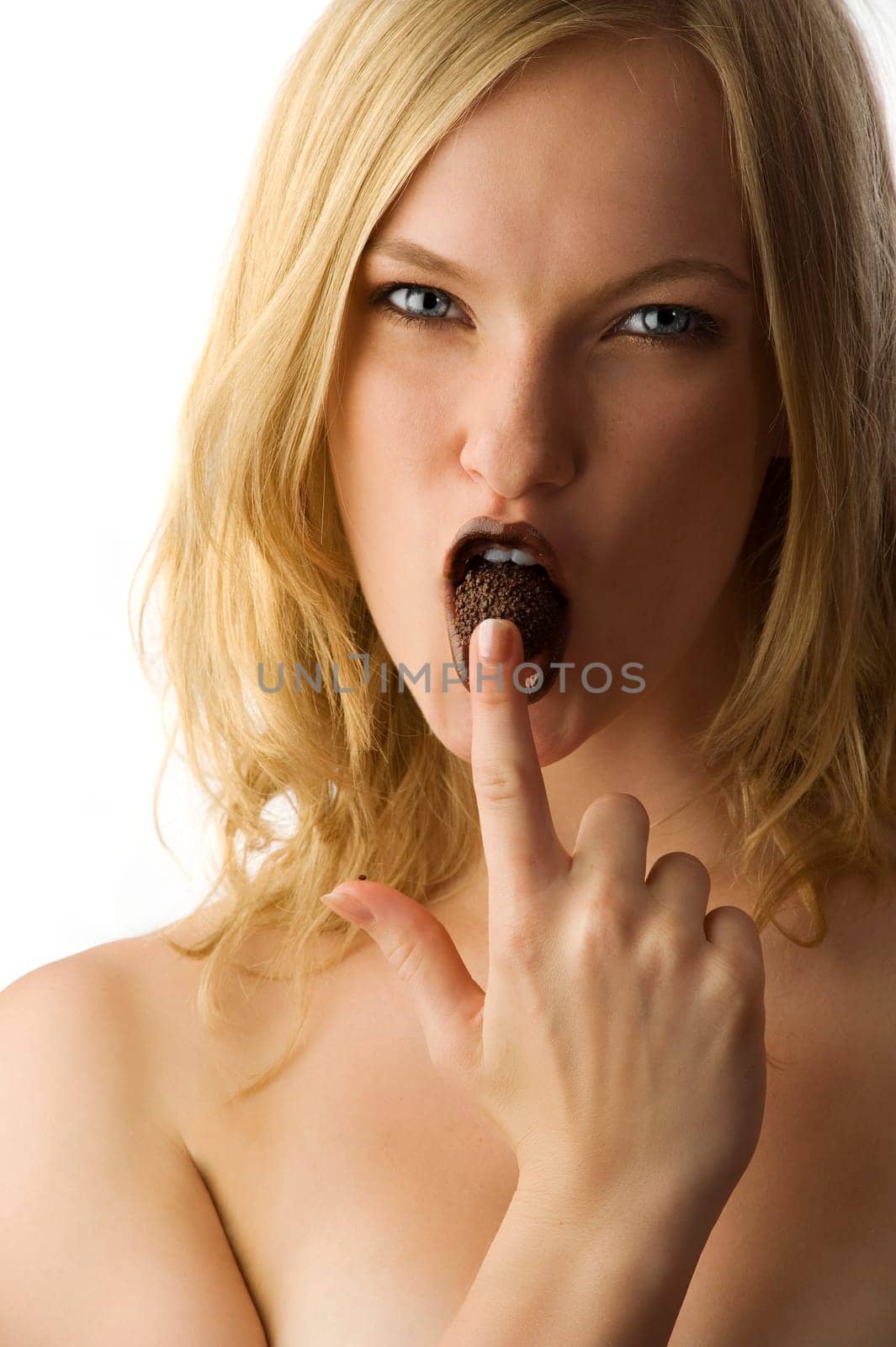 Close-up of fresh and beautiful young model with a chocolate candy between lips