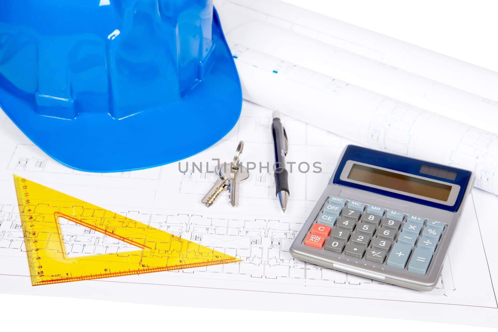 Construction plans with hard hat and drawing tools. Shallow depth of field