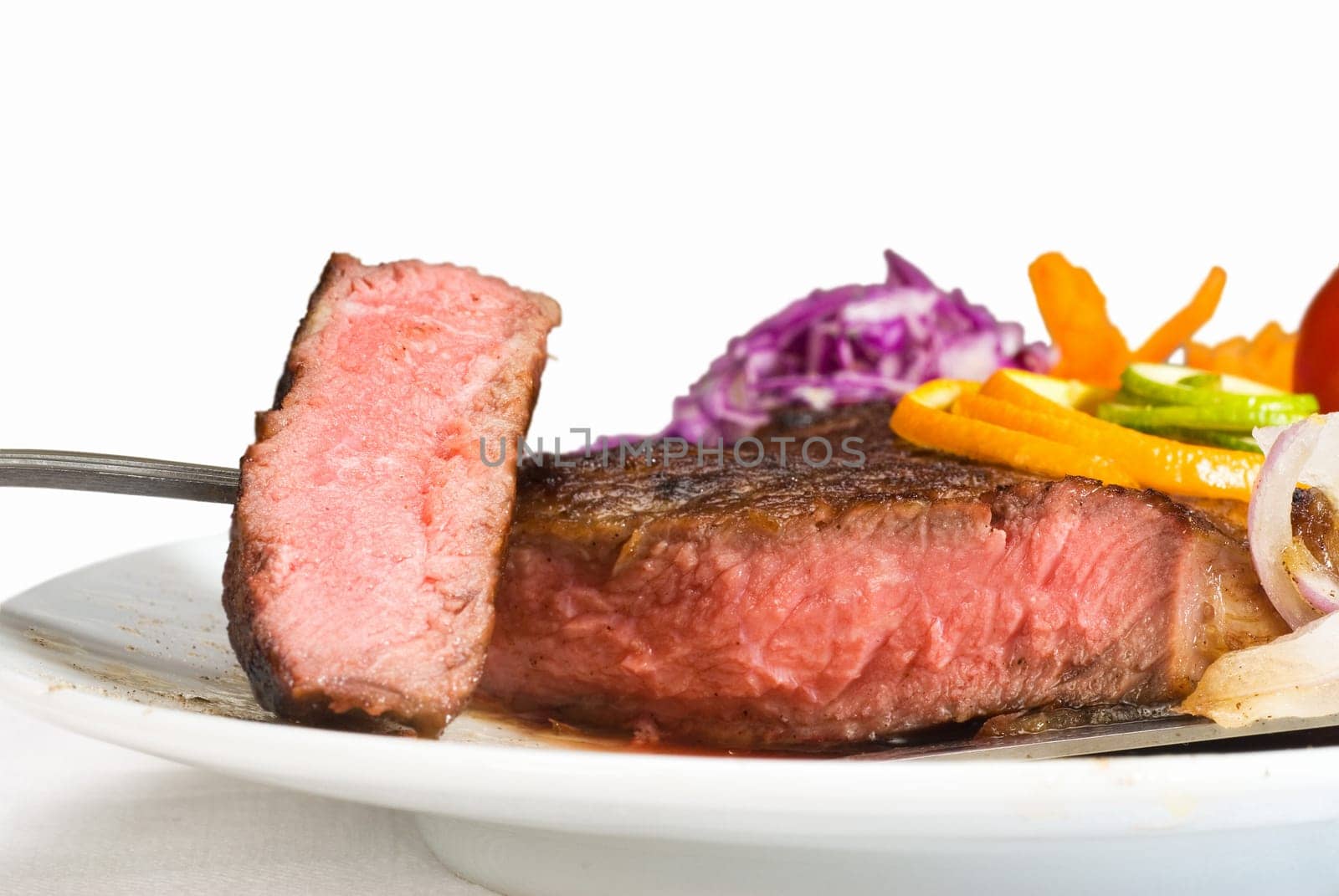 fresh juicy beef ribeye steak sliced ,with lemon and orange peel on top  and vegetable beside