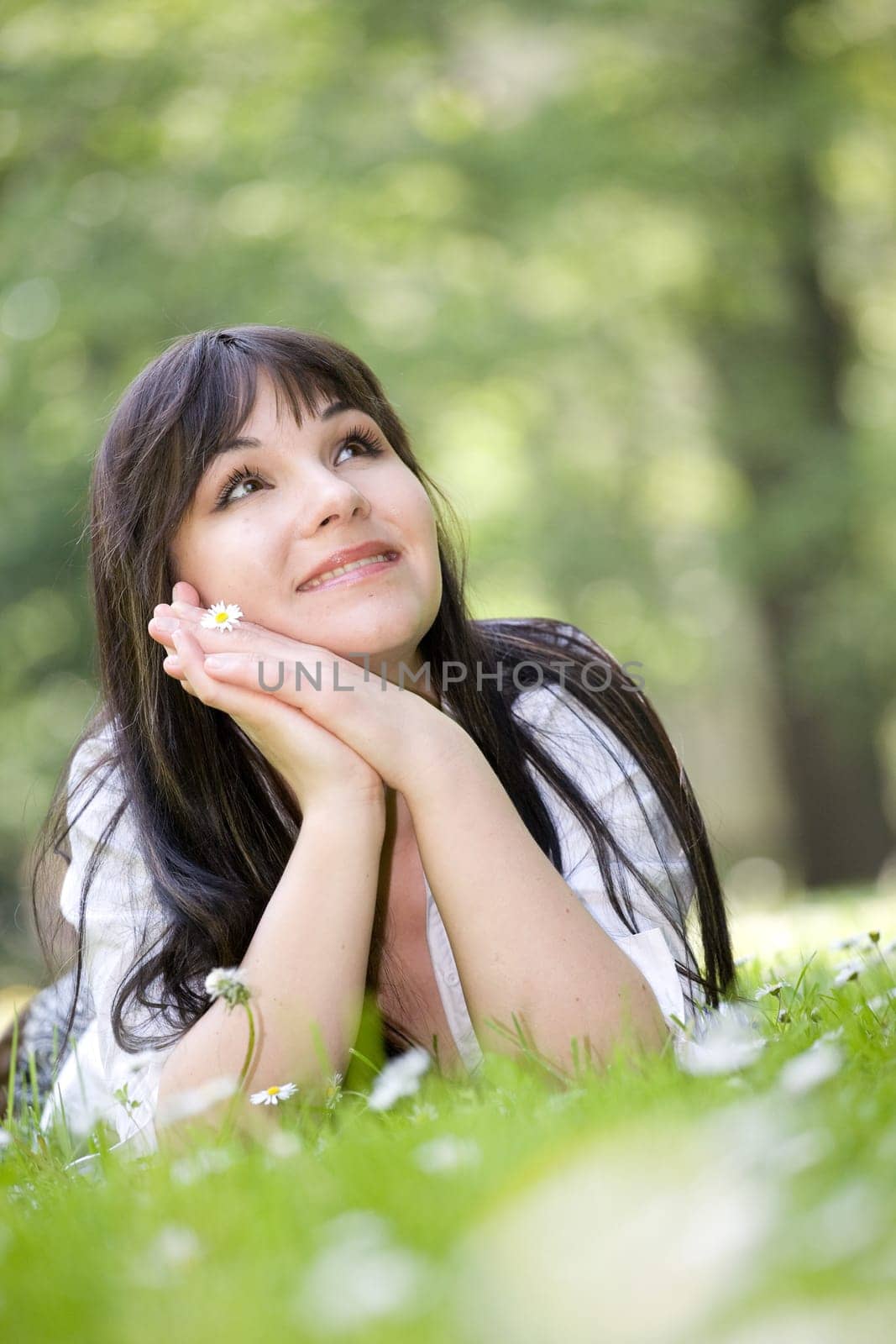 attractive brunette woman relaxing on grass