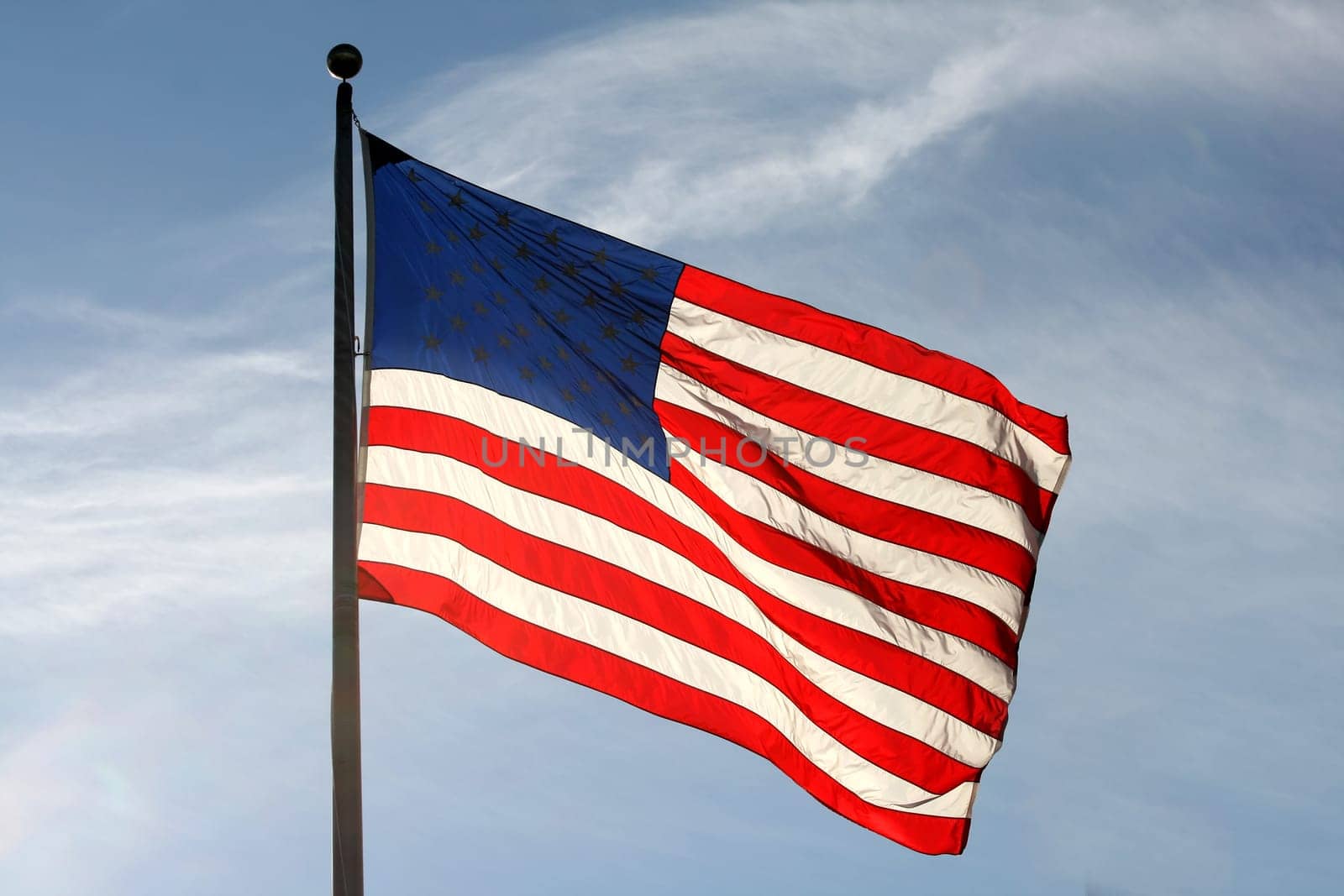 American flag waving against blue sky