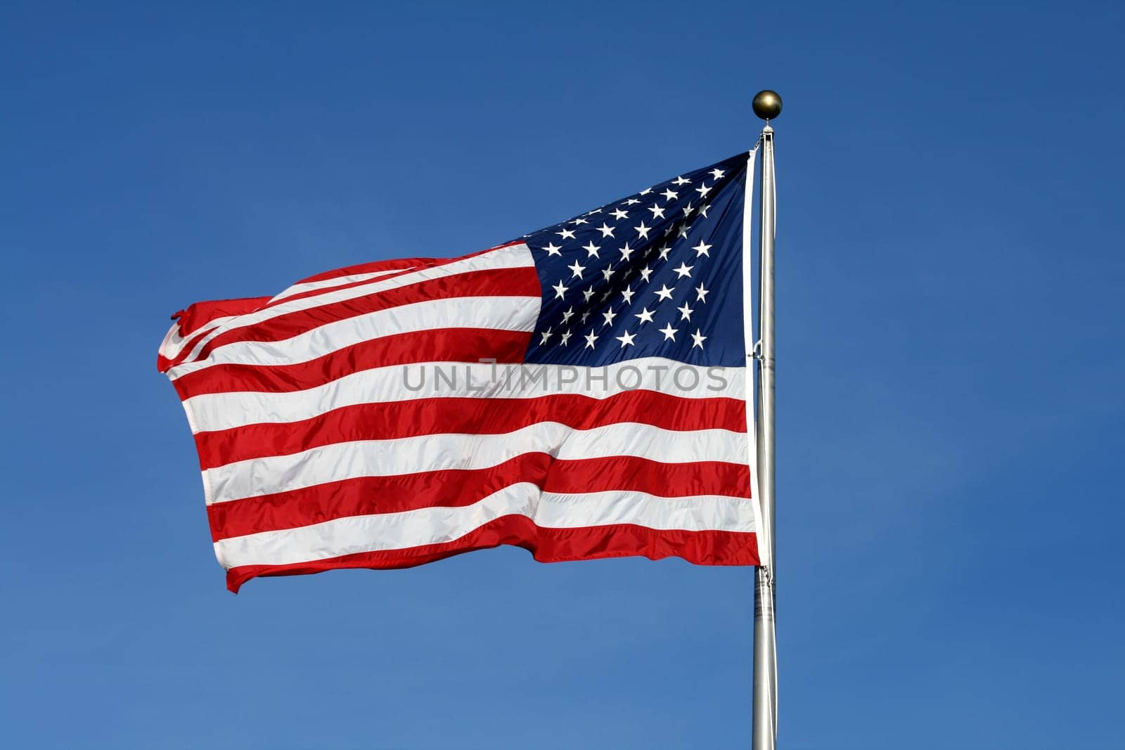 American flag waving against blue sky