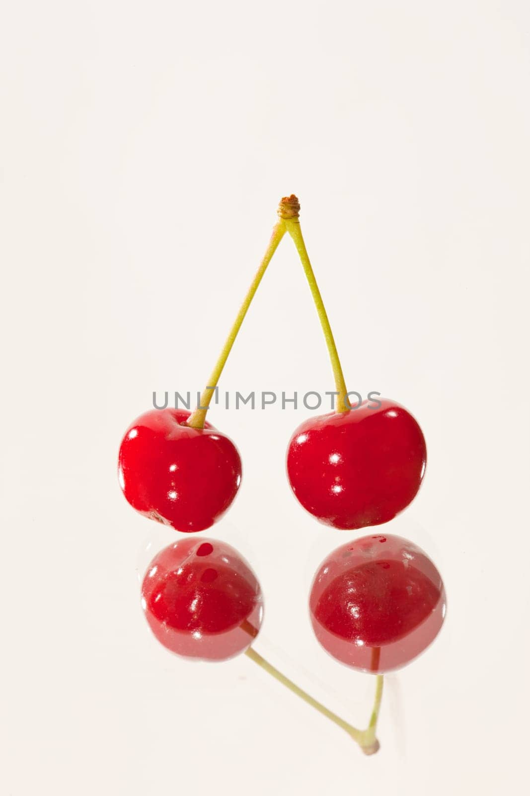 food series: two cherries on reflective sutface