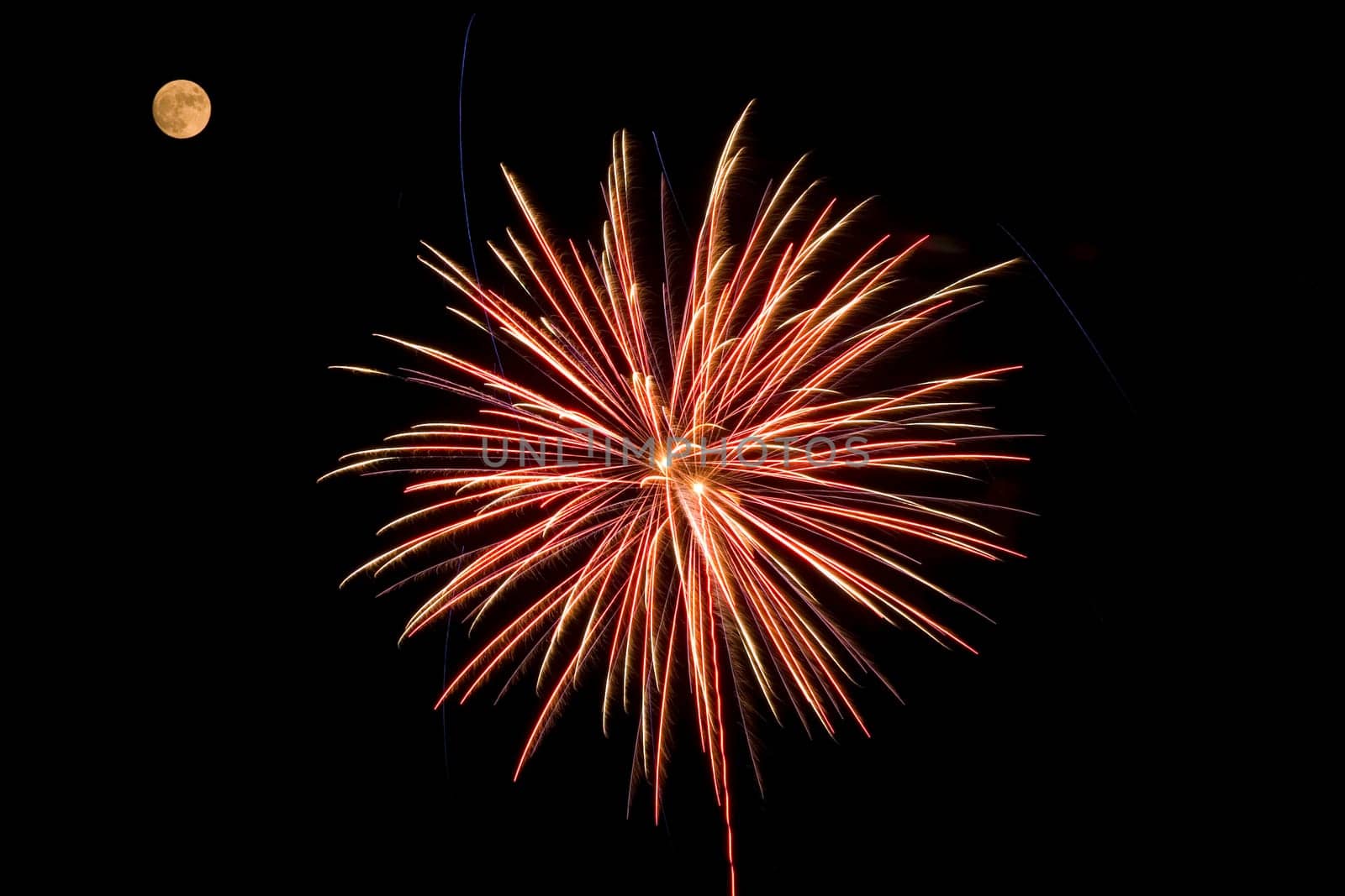 A red and yellow fireworks bursting near the moon.