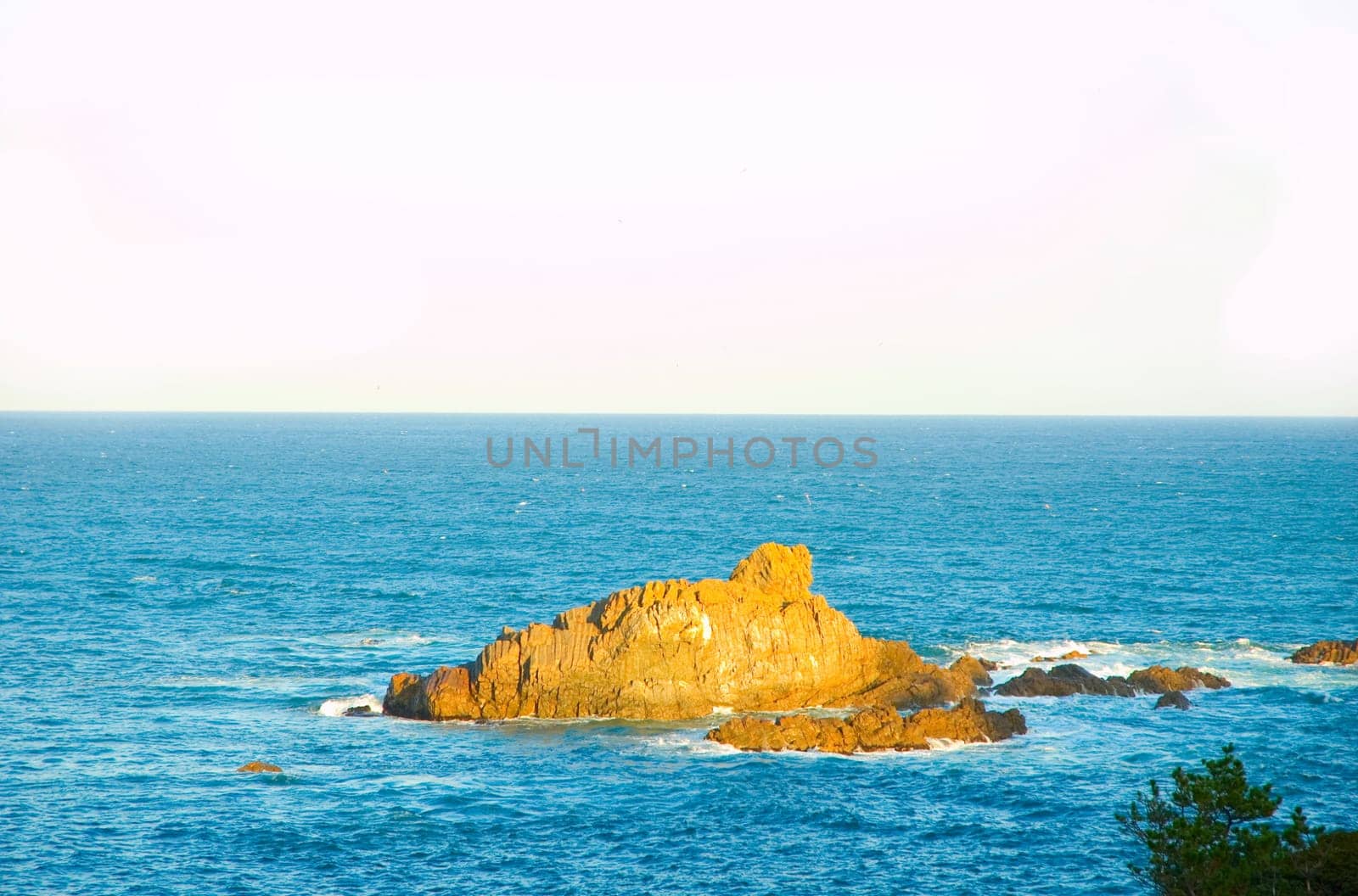 Beautiful landscape with rock in the sea with sunset light