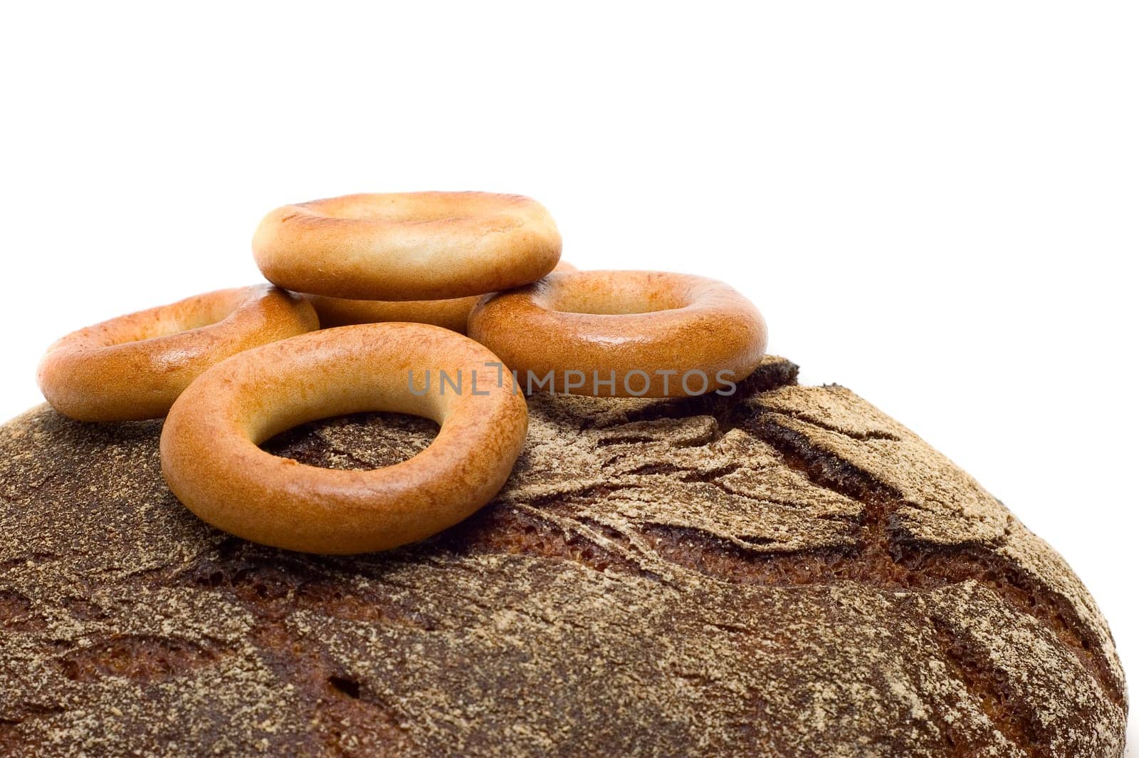 Loaf of bread and bread ring on white background