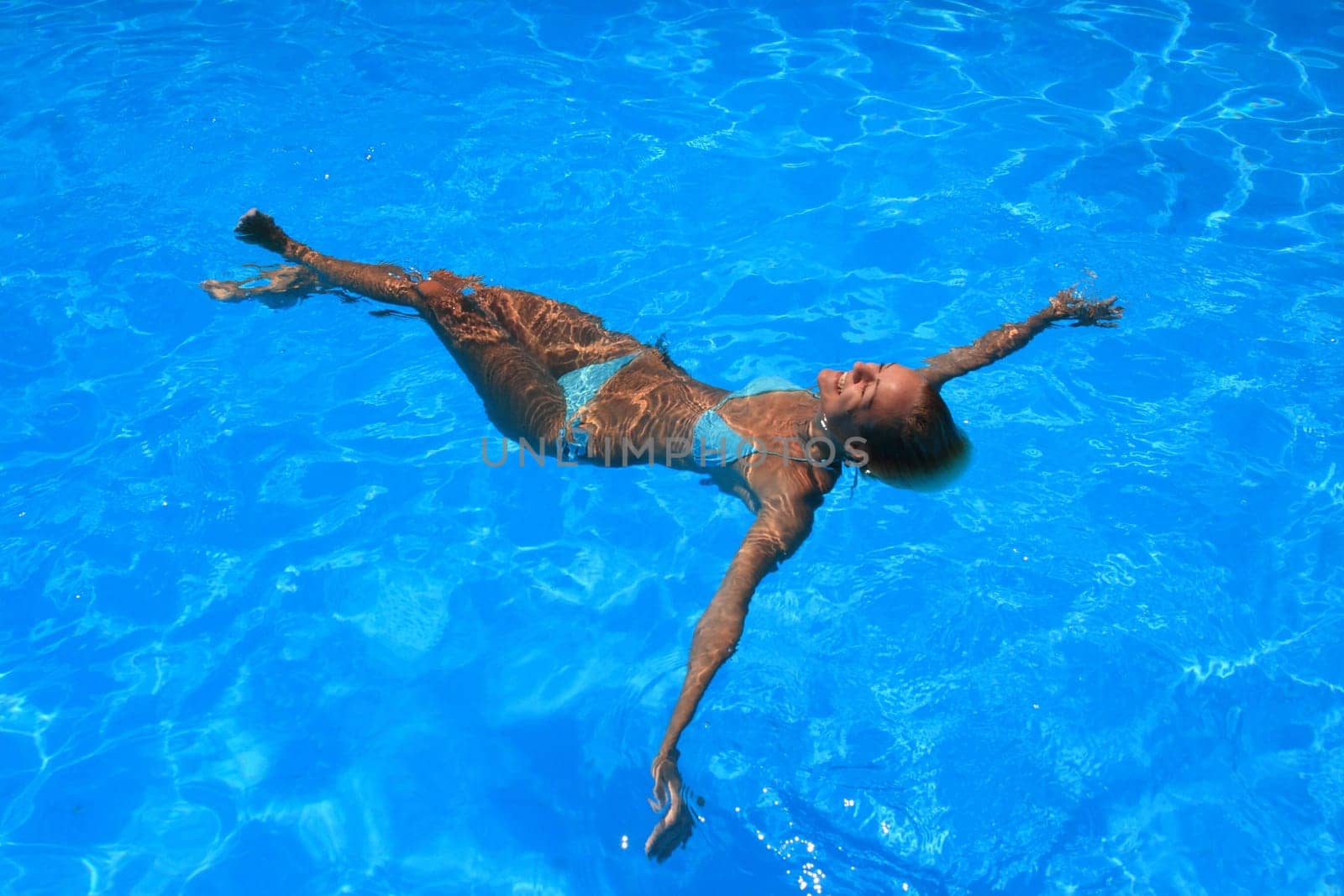 Pretty woman enjoying a swimming pool in Greece