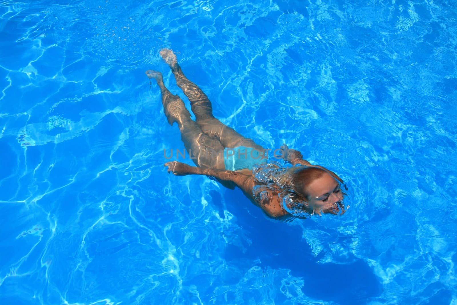 Pretty woman enjoying a swimming pool in Greece