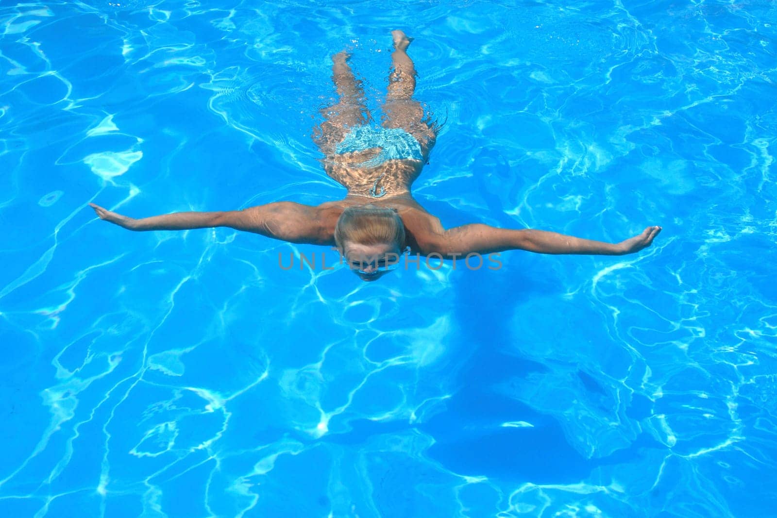 Pretty blonde woman enjoying a swimming pool in Greece