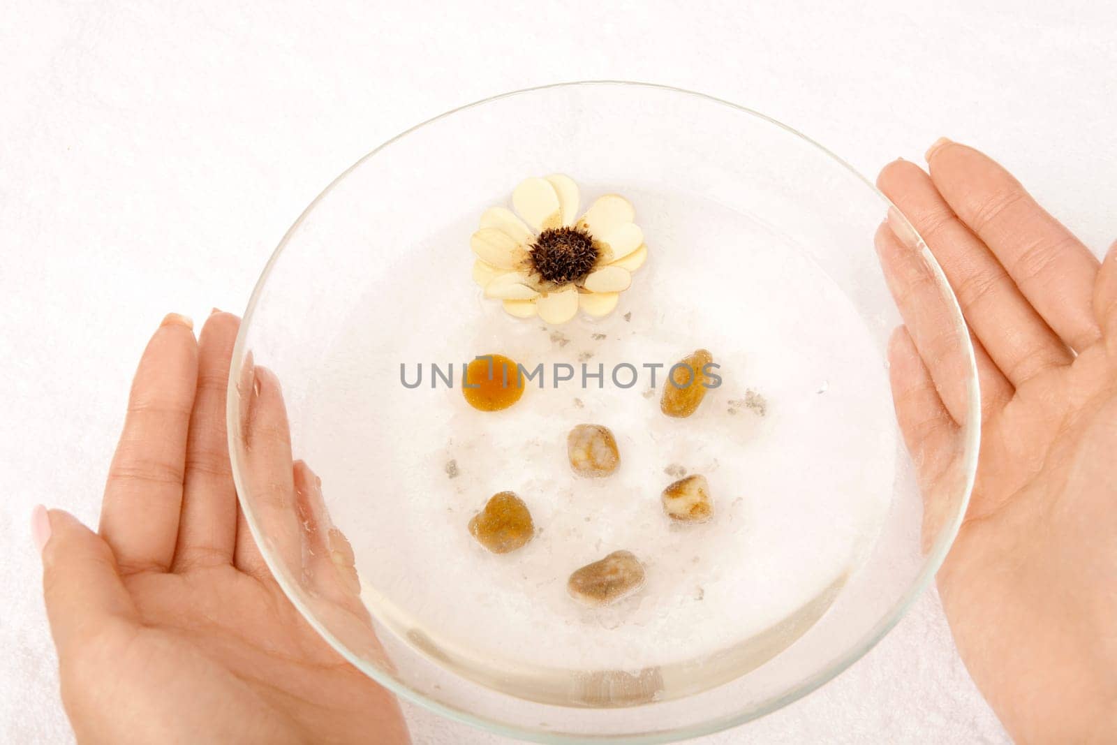Female hands hold a cup with the salt cosmetic solution, isolated