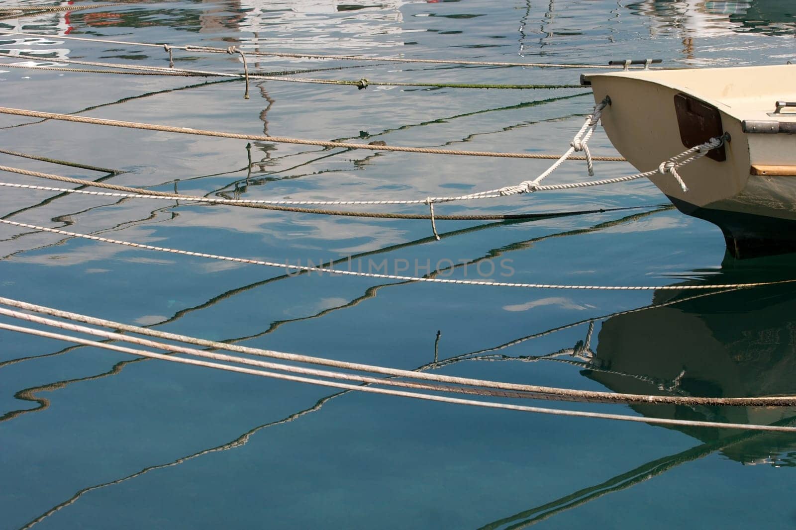 Fishing boats with ropes reflecting in the water surface