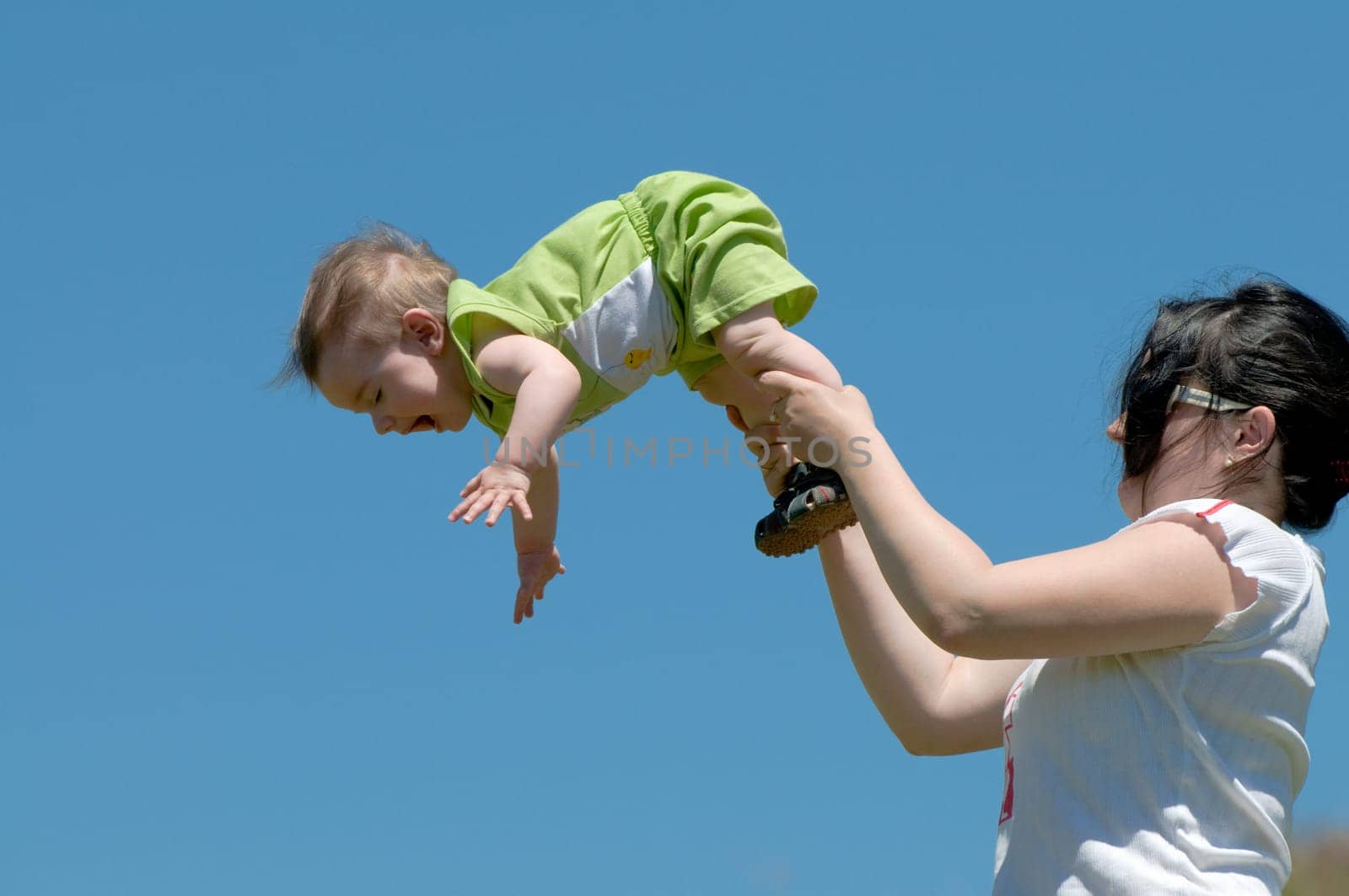 a mummy is playing with his little son outdoors