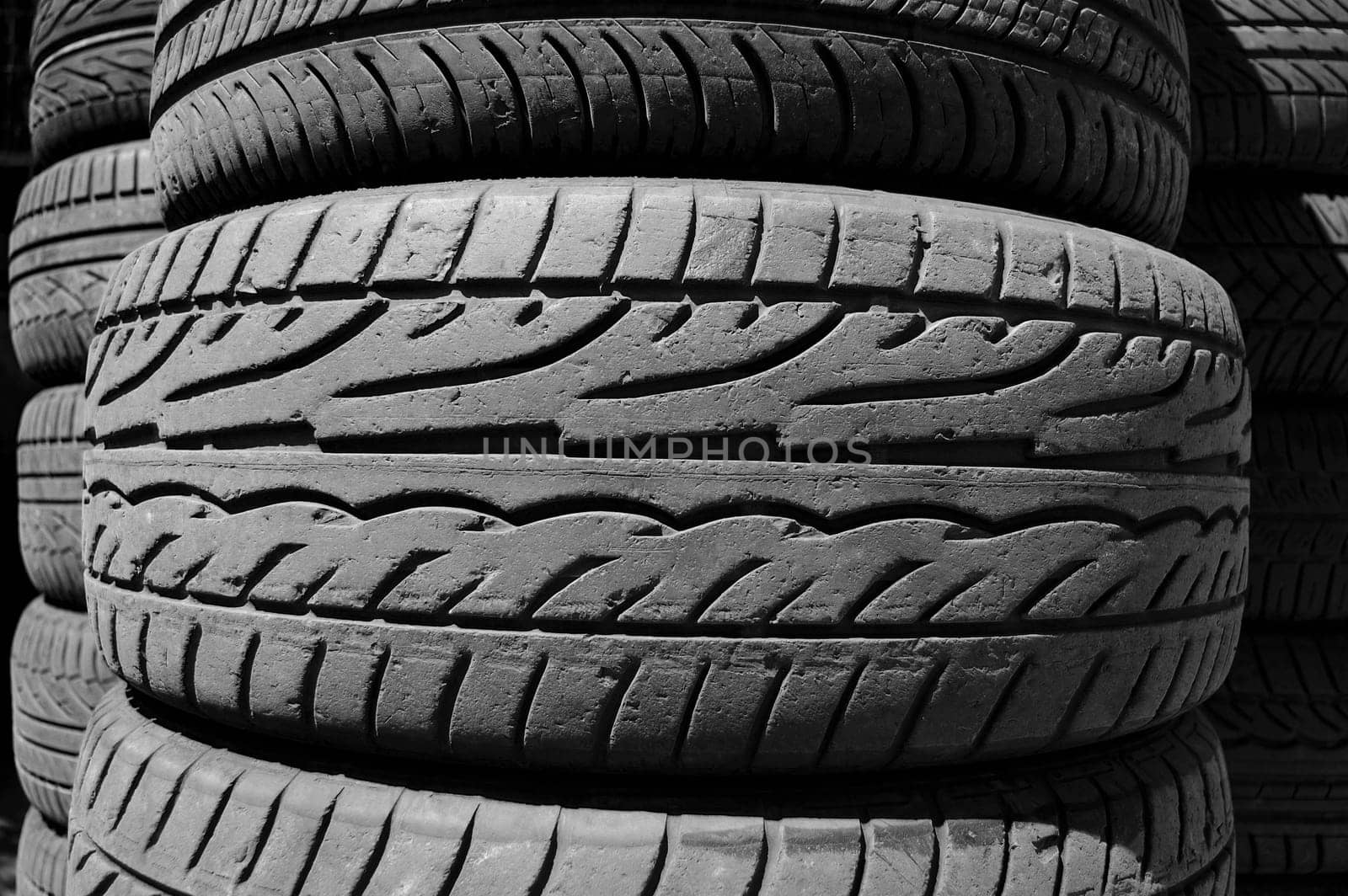 Pile of used car tires background. Black and white.