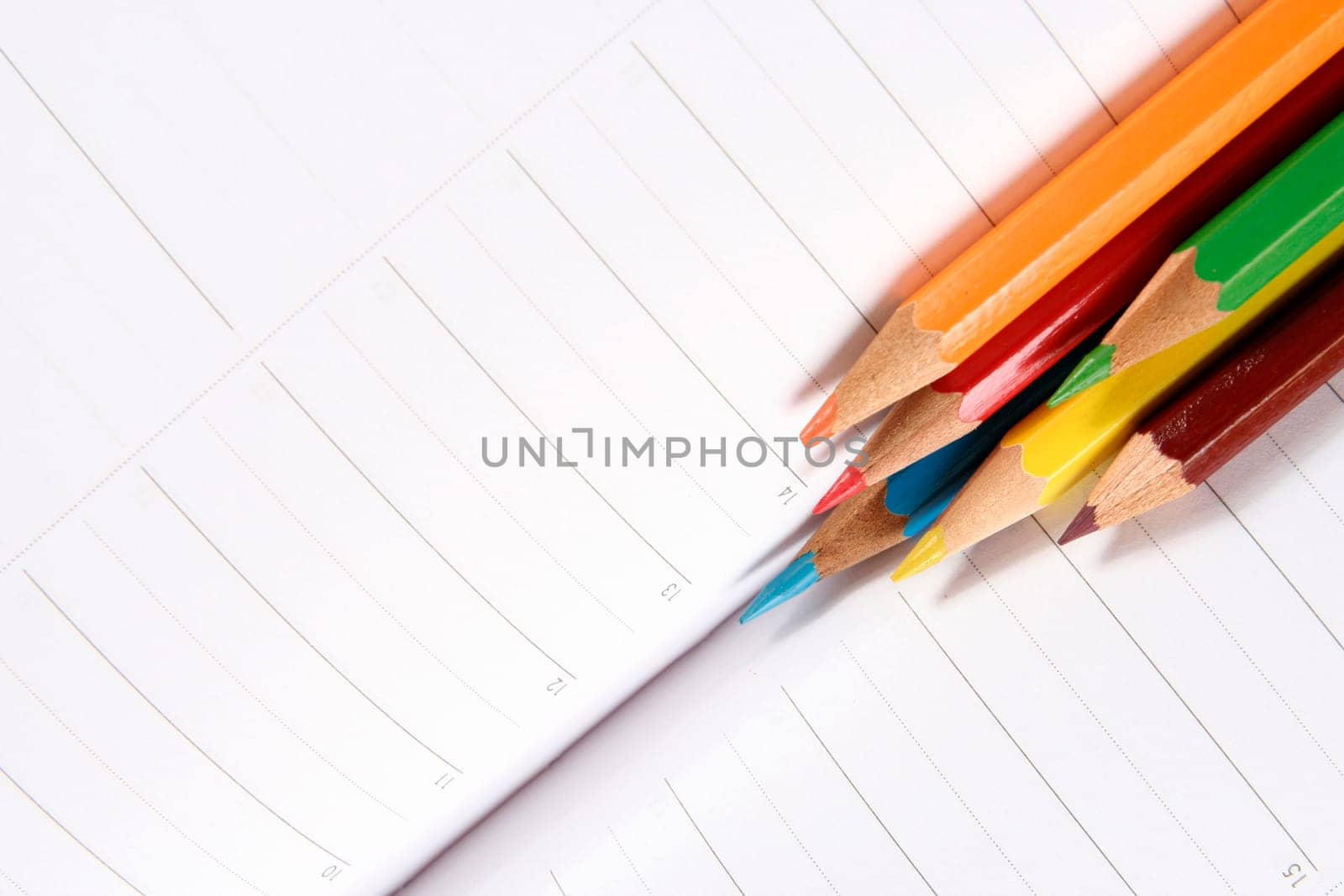 Close-up of color pencils and agenda