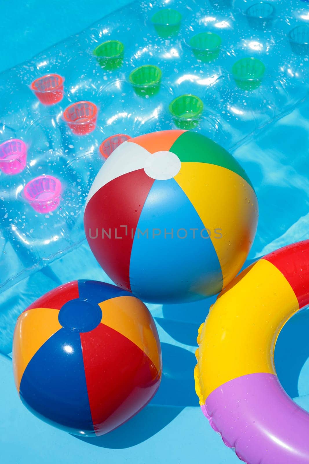 Beach balls, a rubber ring and a lilo in a nice blue pool