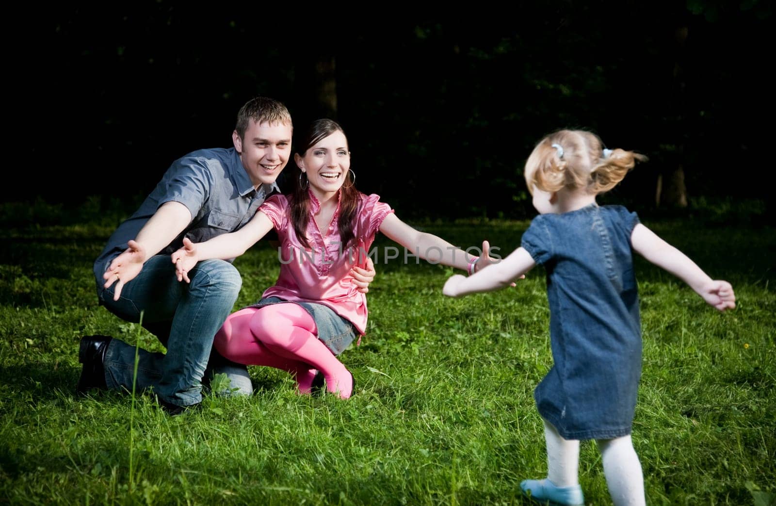 Happy Family Playing On The Grass
