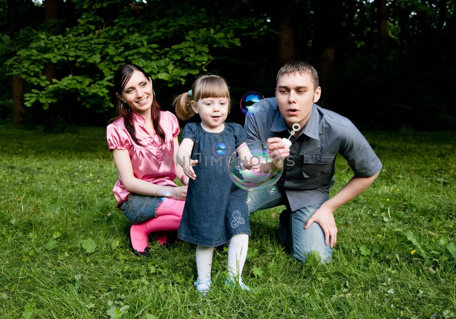 Soap Bubbles. Family Playing In The Park.