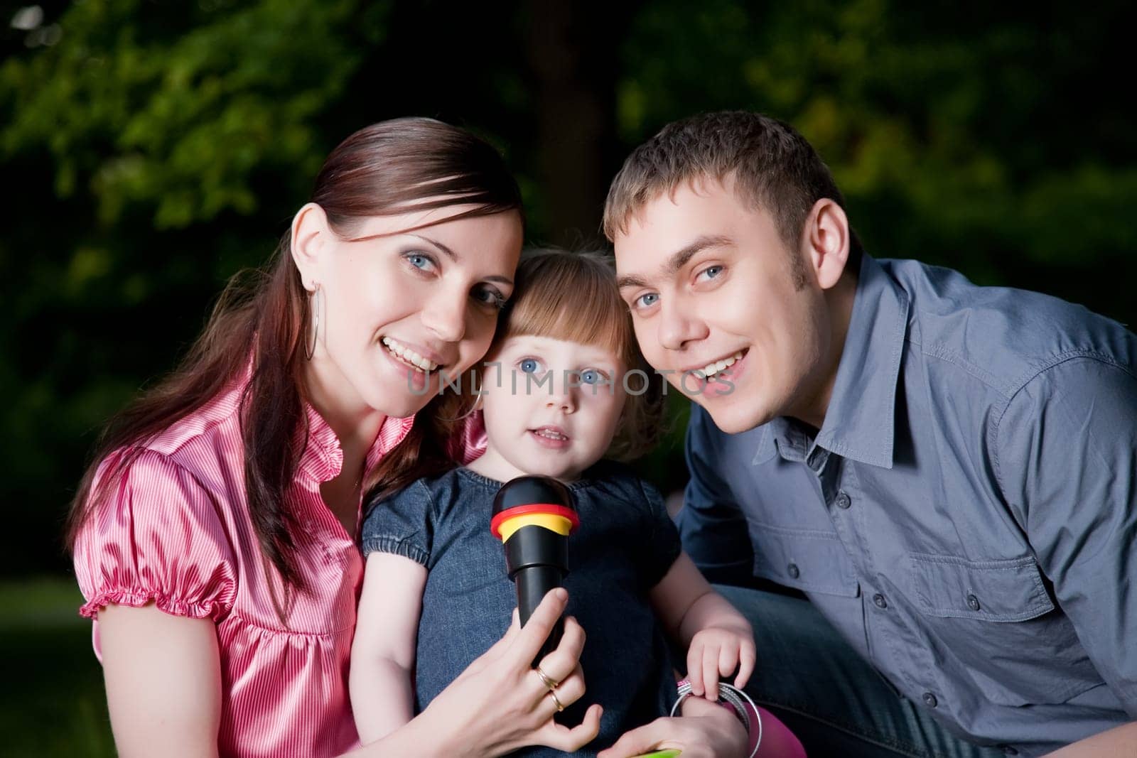 Happy Family. Father, Mother And Daugther In The Park