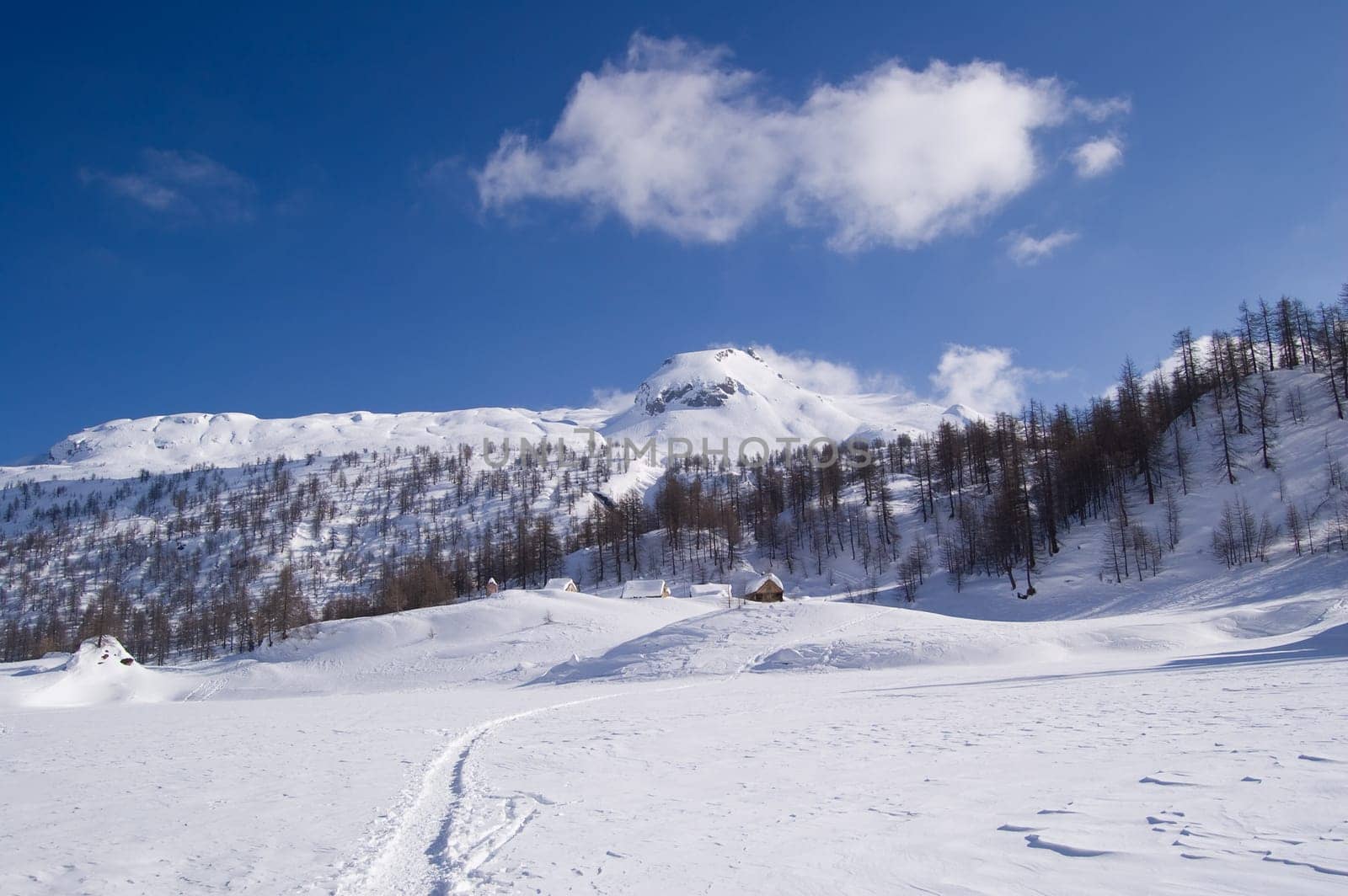 icy alpine lake landscape full of snow with a small village on the top  Alps, Italy