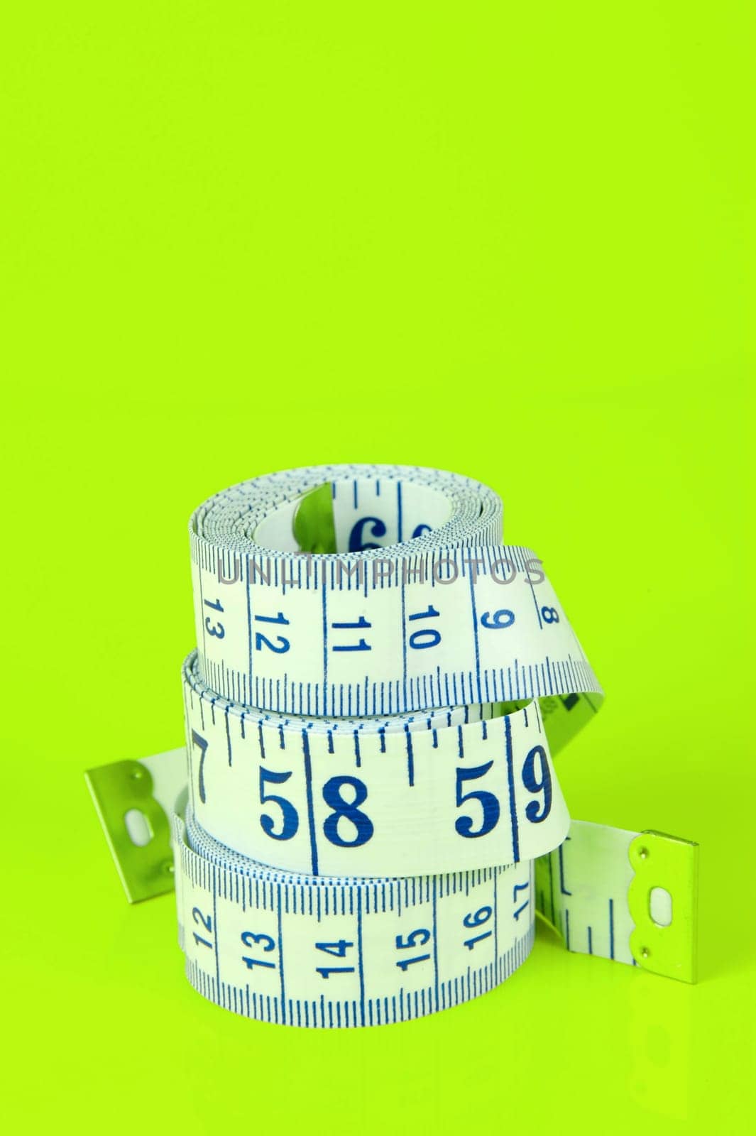 A measuring tape isolated agaist a lime green background