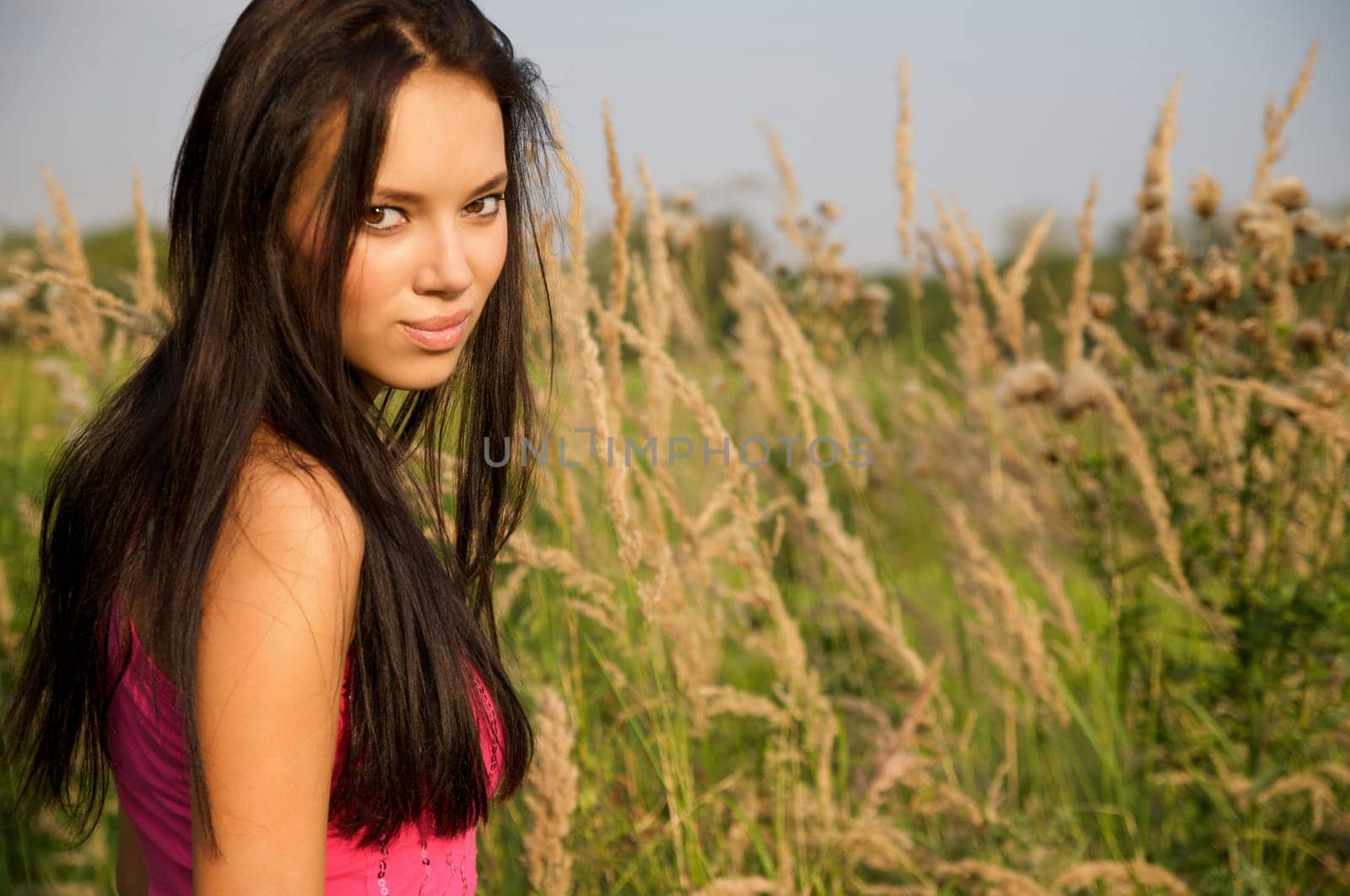 Portrait of a young beautiful woman in the thick grass
