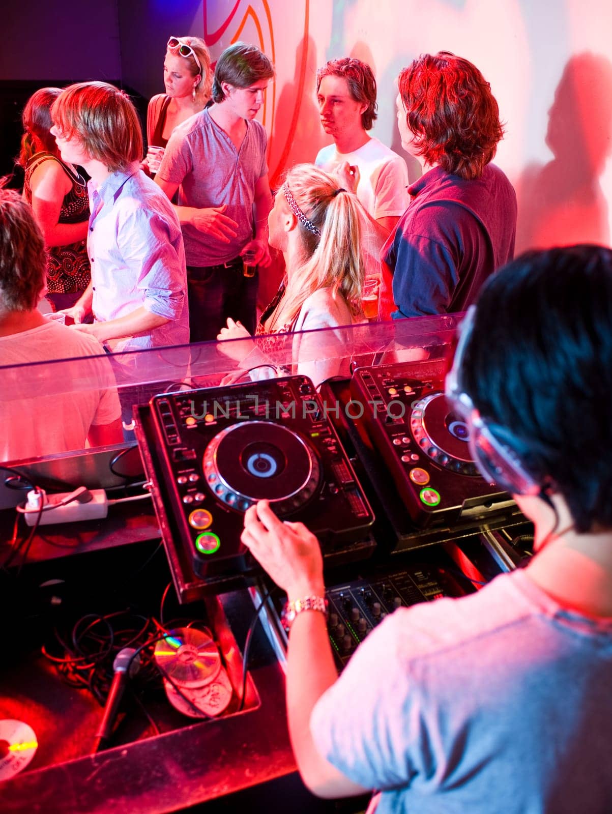 Party in a nightclub viewed from the DJ booth