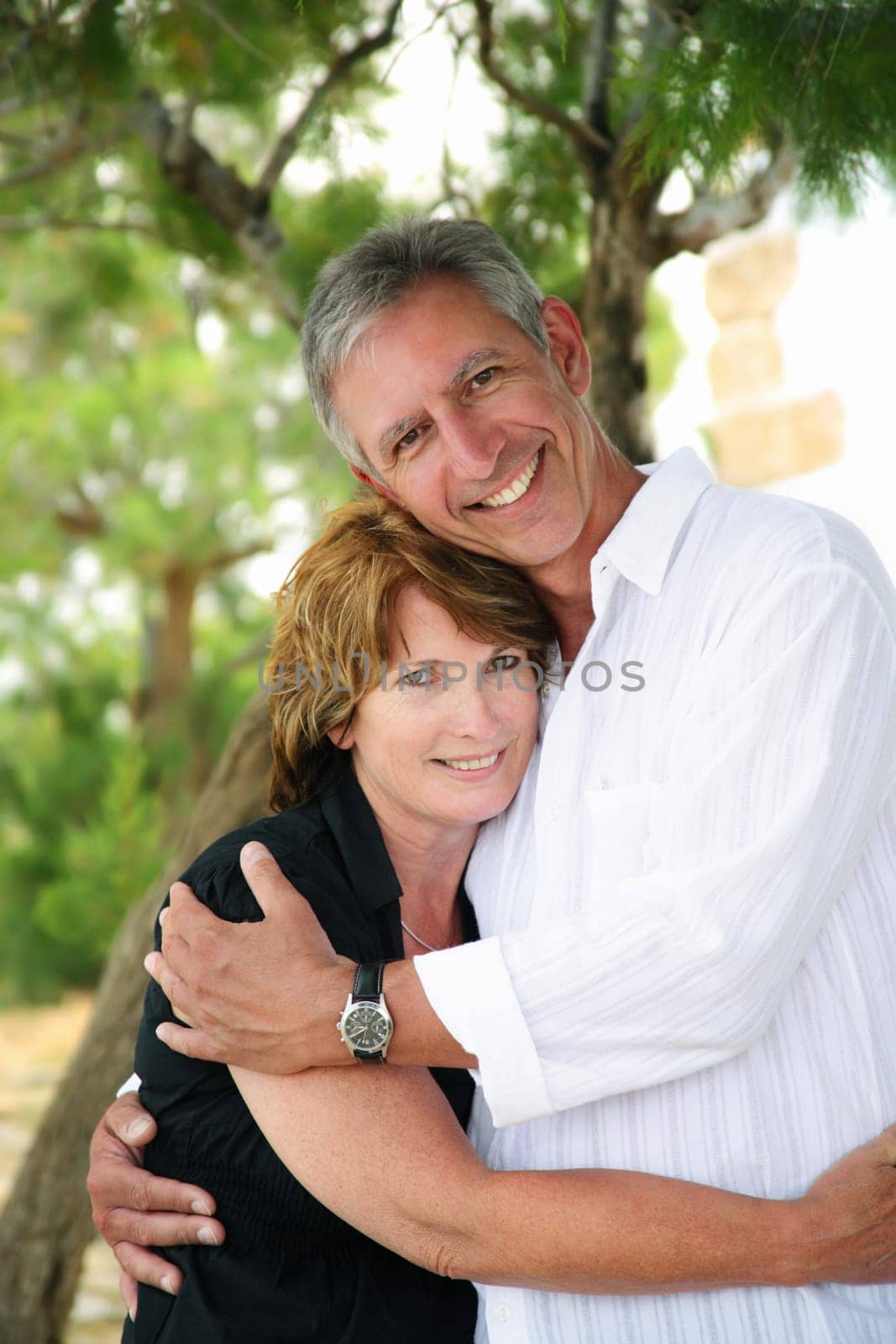 beautiful mature couple holding each other and looking at the camera