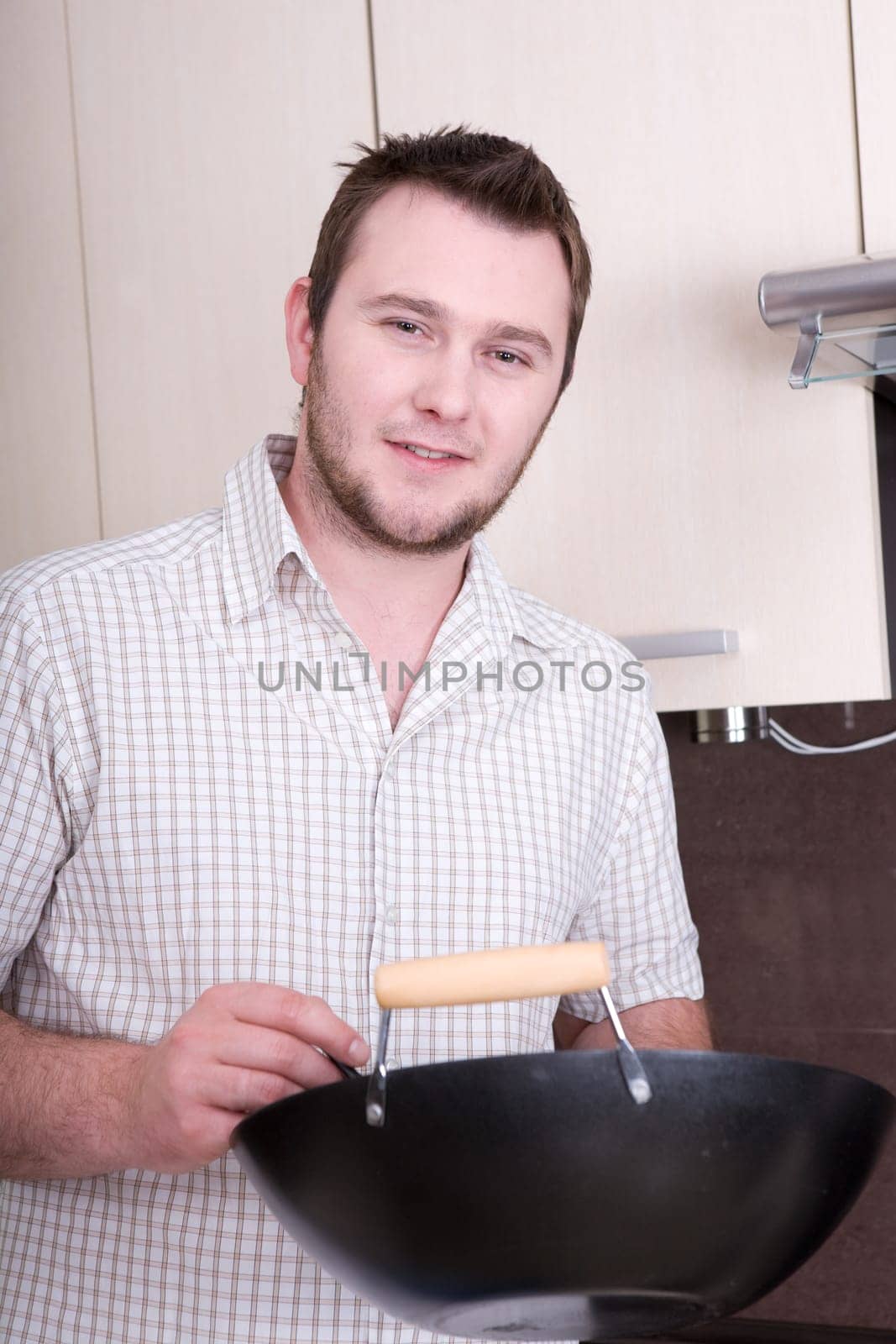 happy casual man cooking dinner in kitchen