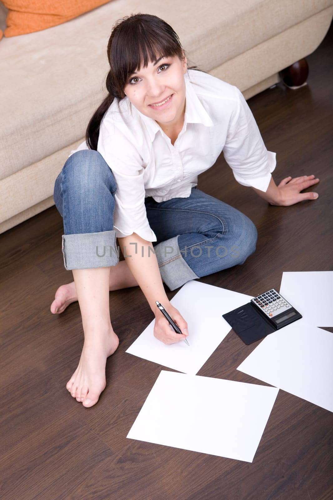 happy young woman with calculator at home