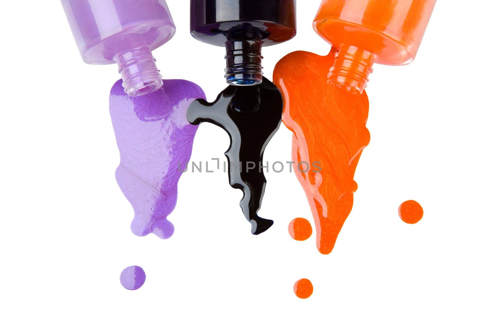 The colour nail polish which is pouring out from bottles on a white background