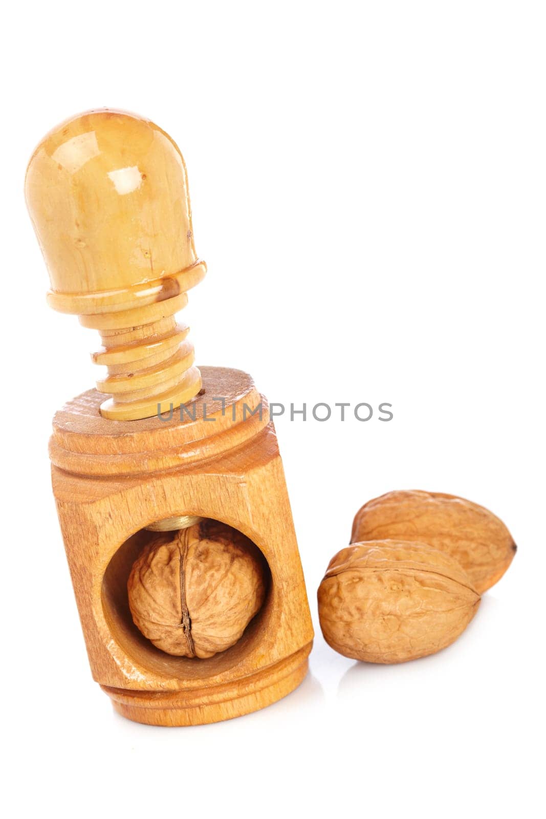 Some walnuts and wood nutcracker reflected on white background