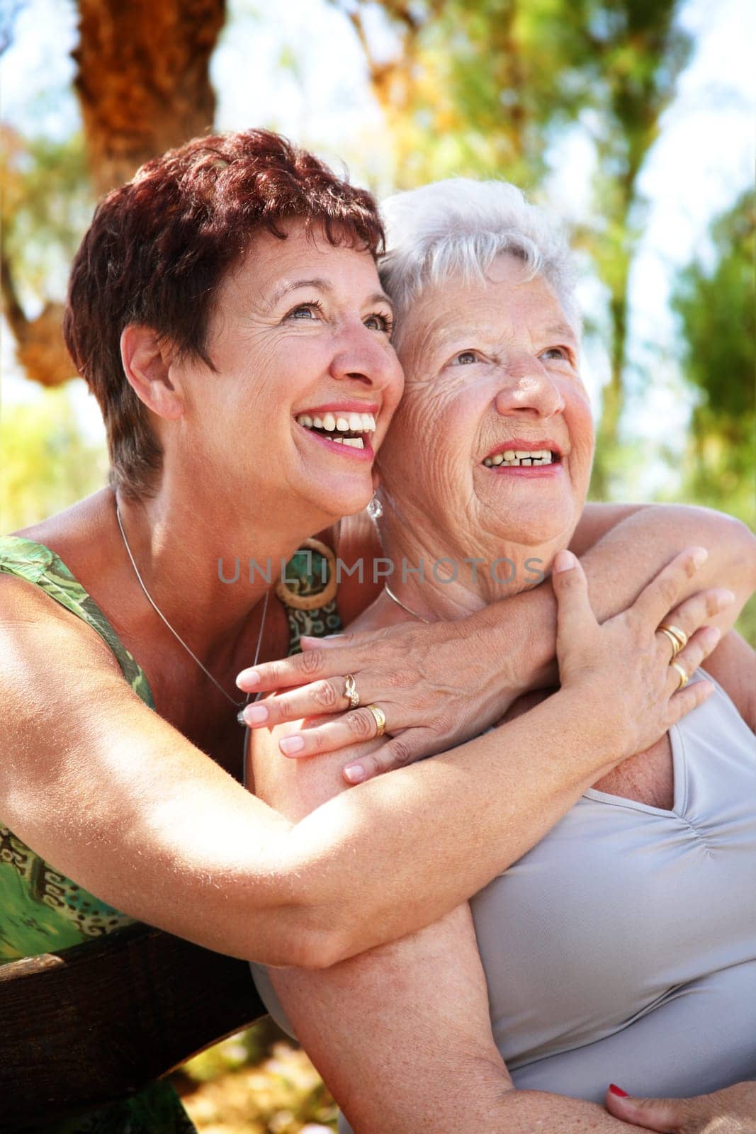 beautiful senior mother and daughter hugging and looking up