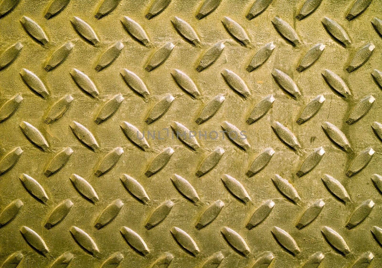 Diamond gold toned metal background texture illuminated by sunlight
