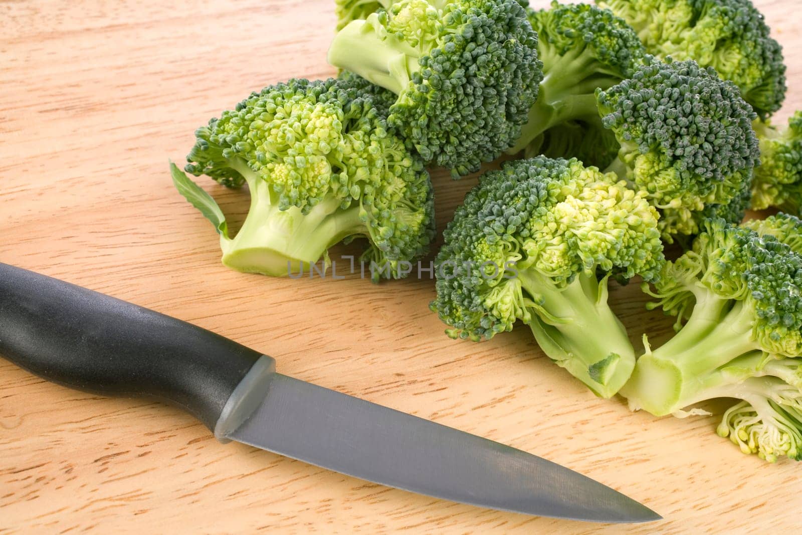 Broccoli on wooden chopping board with knife