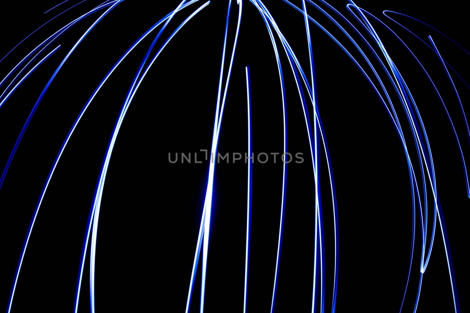 An abstract light background showing motion blurred light on a dark background.